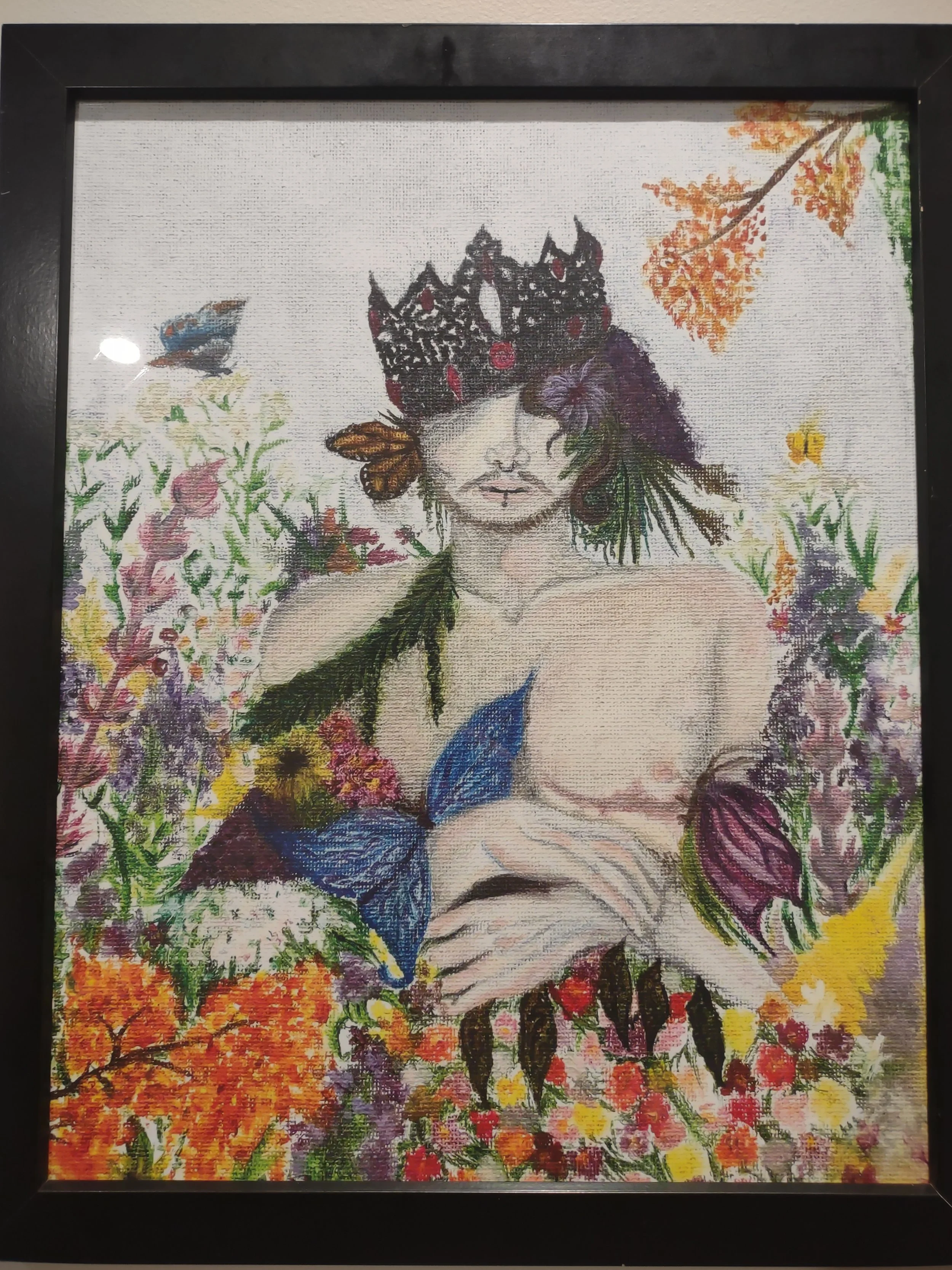 Trans man among flowers and butterflies, a crown on his head
