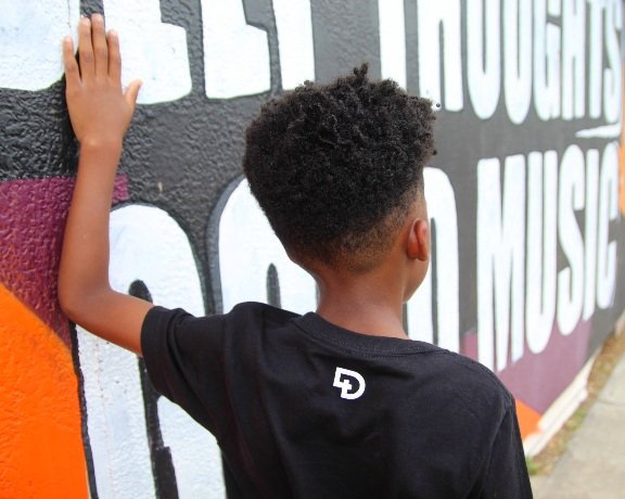 Back view of DxW Youth shirt on little boy showing the logo