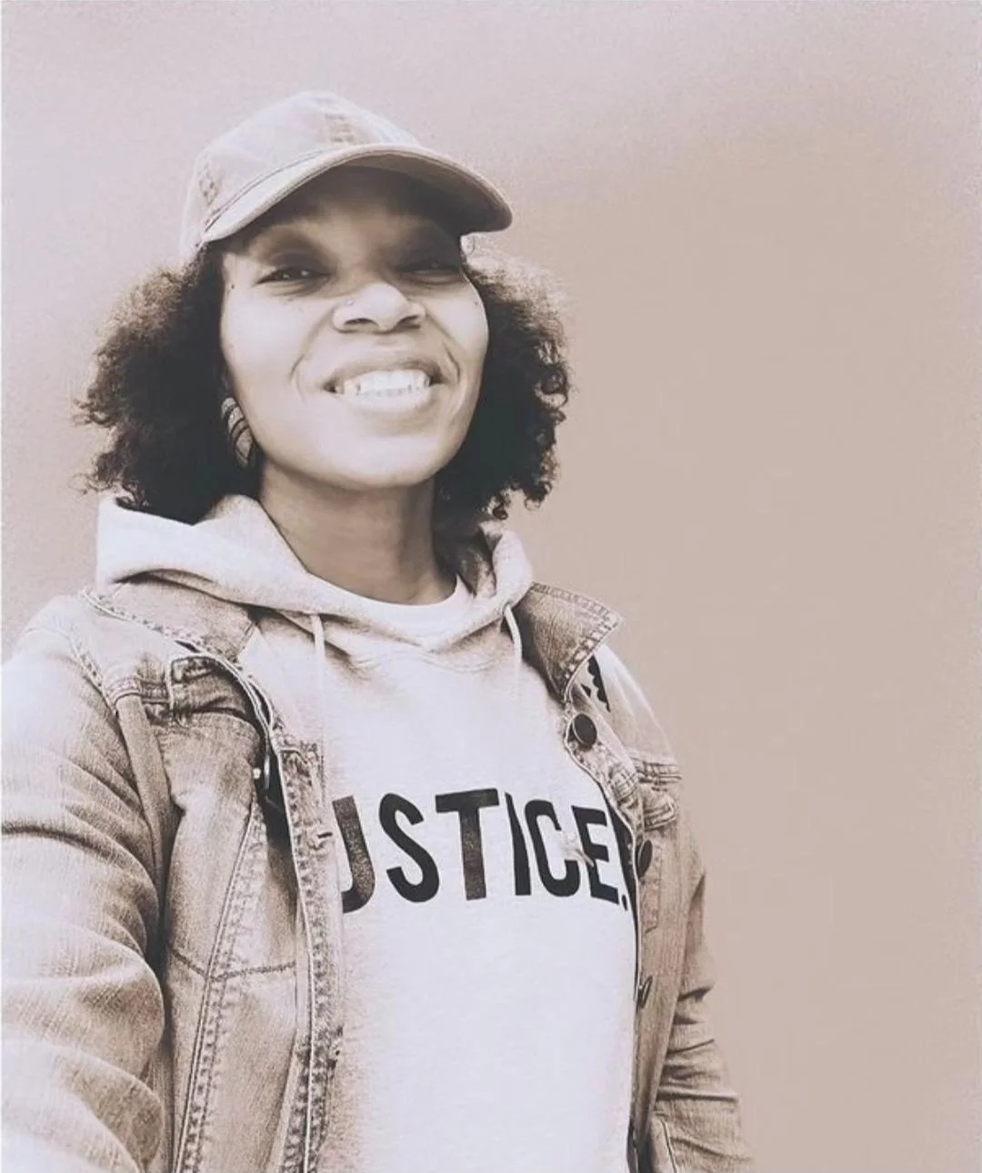 Woman in grey JUSTICE. hoodie