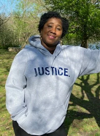Woman in grey JUSTICE. hoodie
