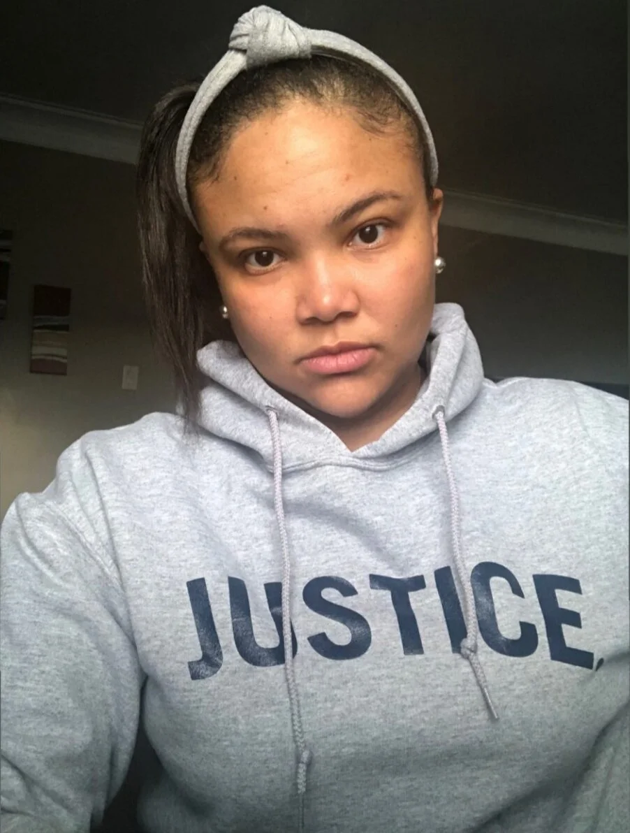 Woman in grey JUSTICE. hoodie
