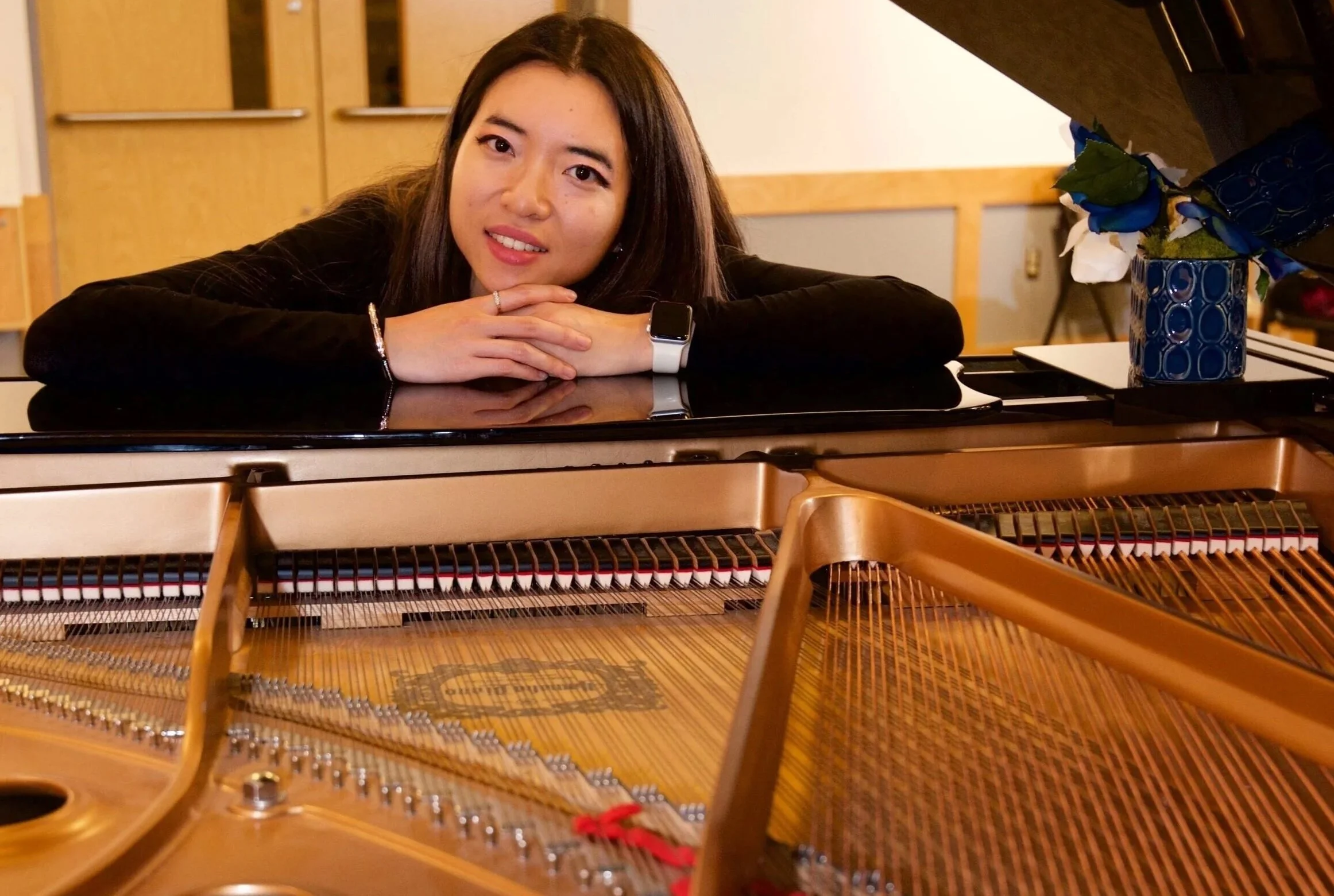 season leaning on a grand piano with strings