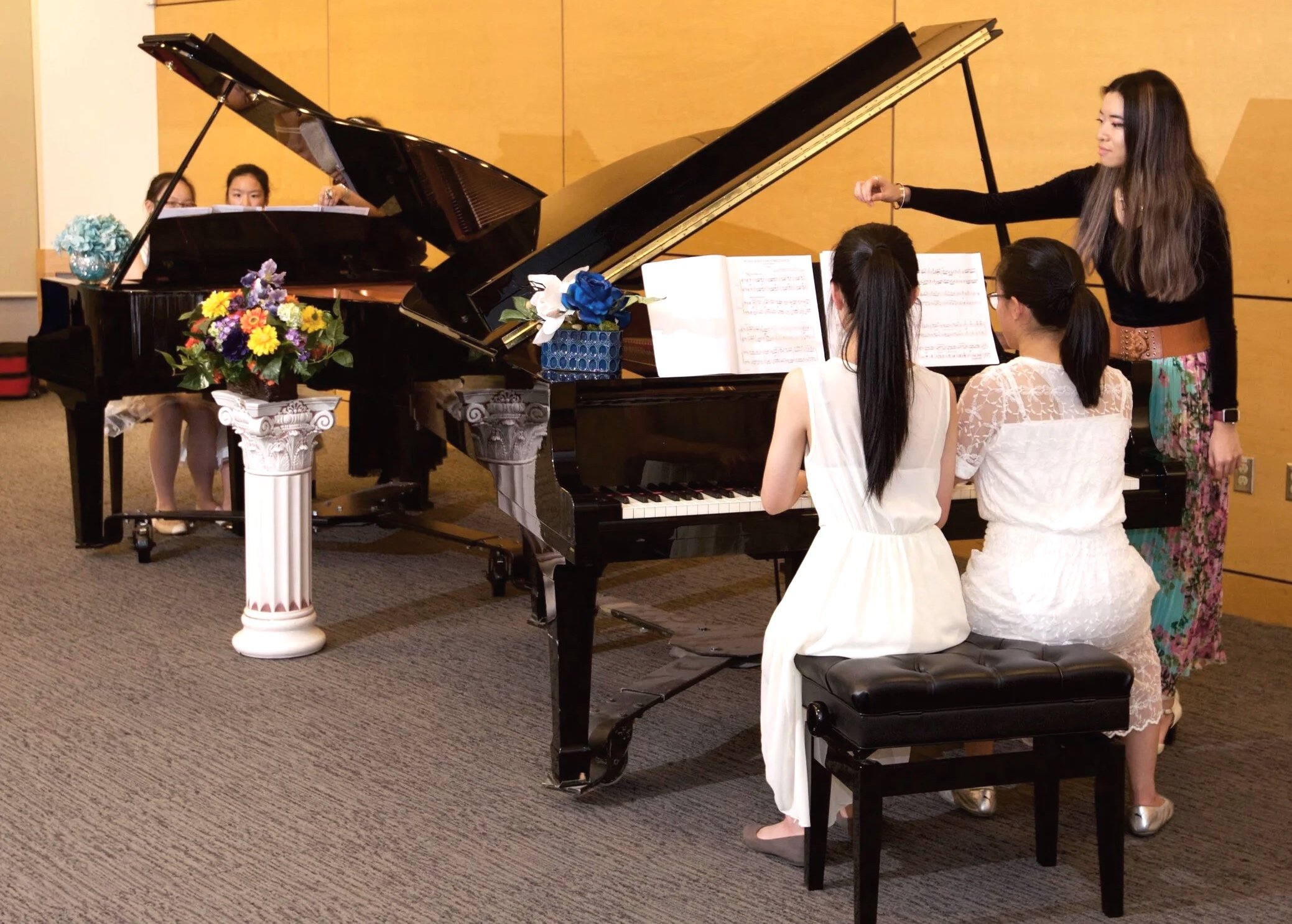 season teaching in front of a grand piano