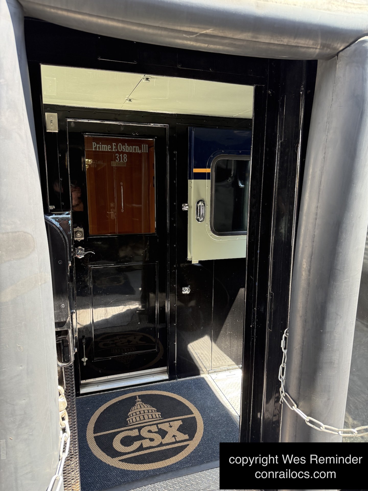 Vestibule area of CSX theater car 994318, featuring a CSX rug at the doorway.