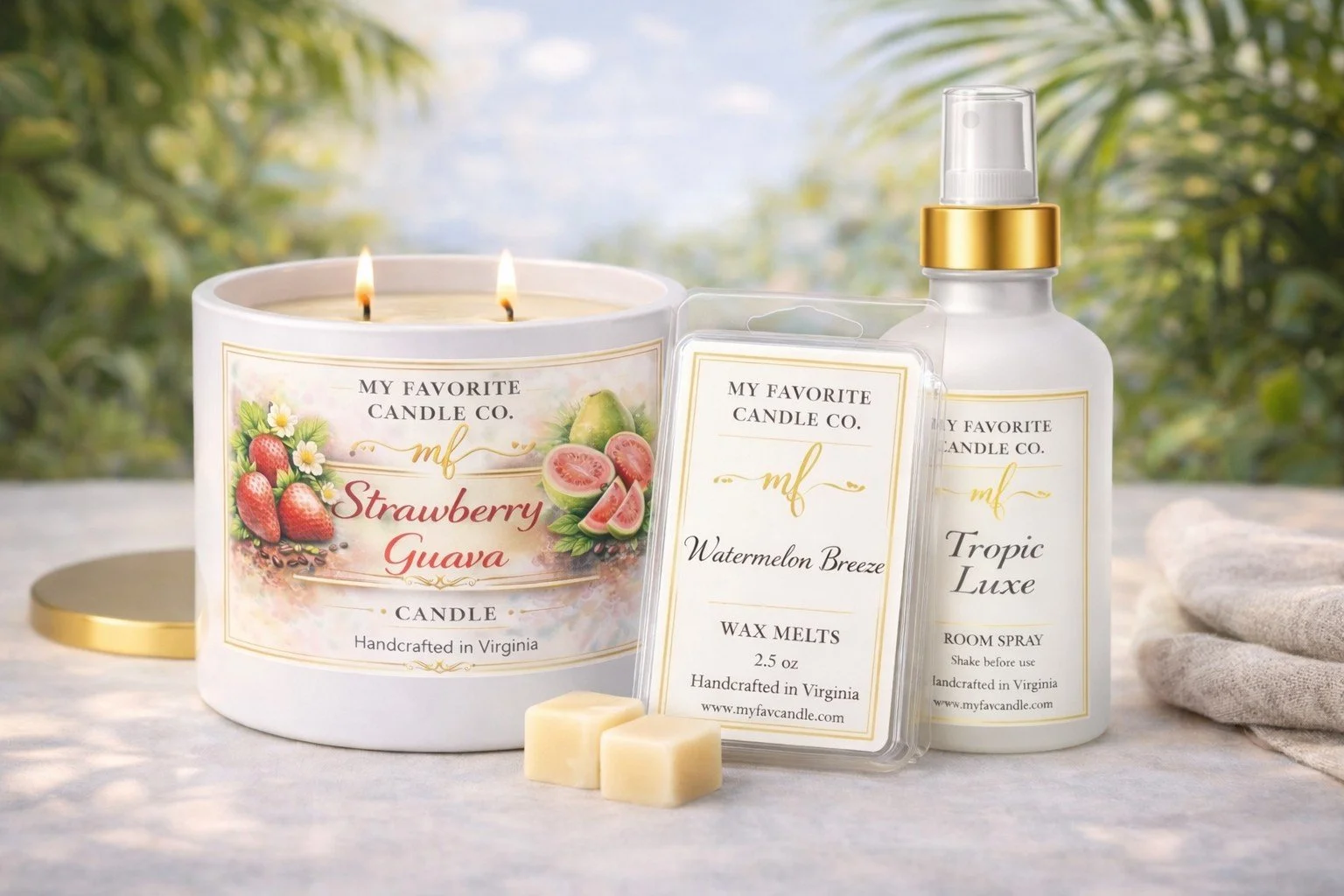 Set of scented products including a strawberry guava scented candle, watermelon breeze wax melts, and tropic luxe room spray, arranged outdoors on a light-colored surface with a blurred green background.