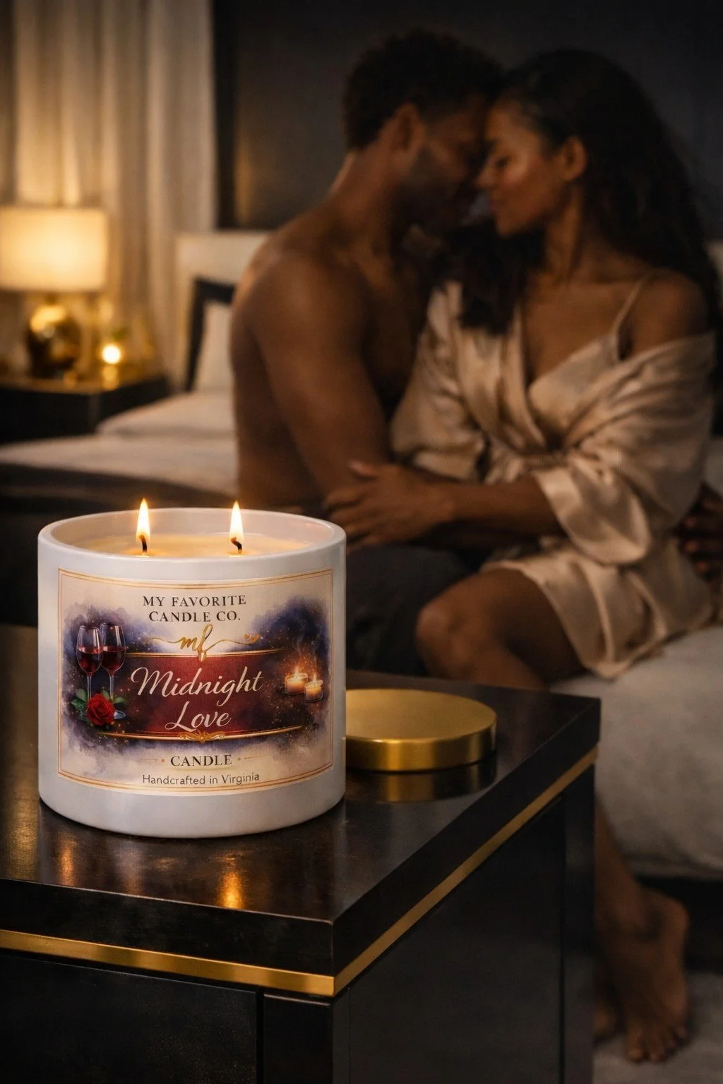 A lit candle labeled 'Midnight Love' on a black table in a dimly lit bedroom with a couple sitting on the bed, touching foreheads, in the background.