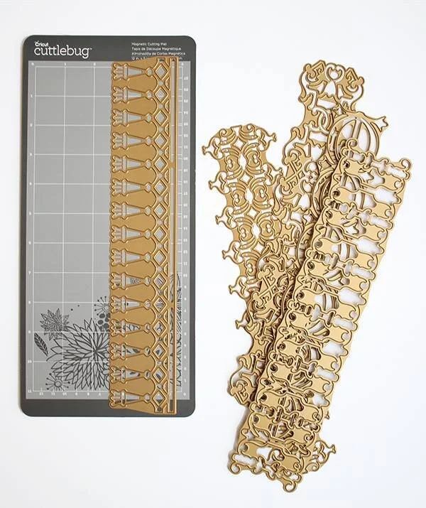 Magnetic metal cutting and embossing dies and a cutting mat on a white surface.