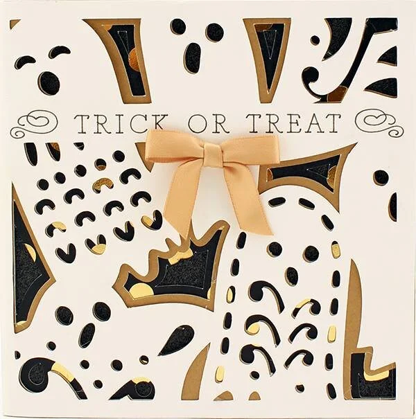 Halloween-themed card with cut-out shapes, a beige ribbon bow, and the words "Trick or Treat"
