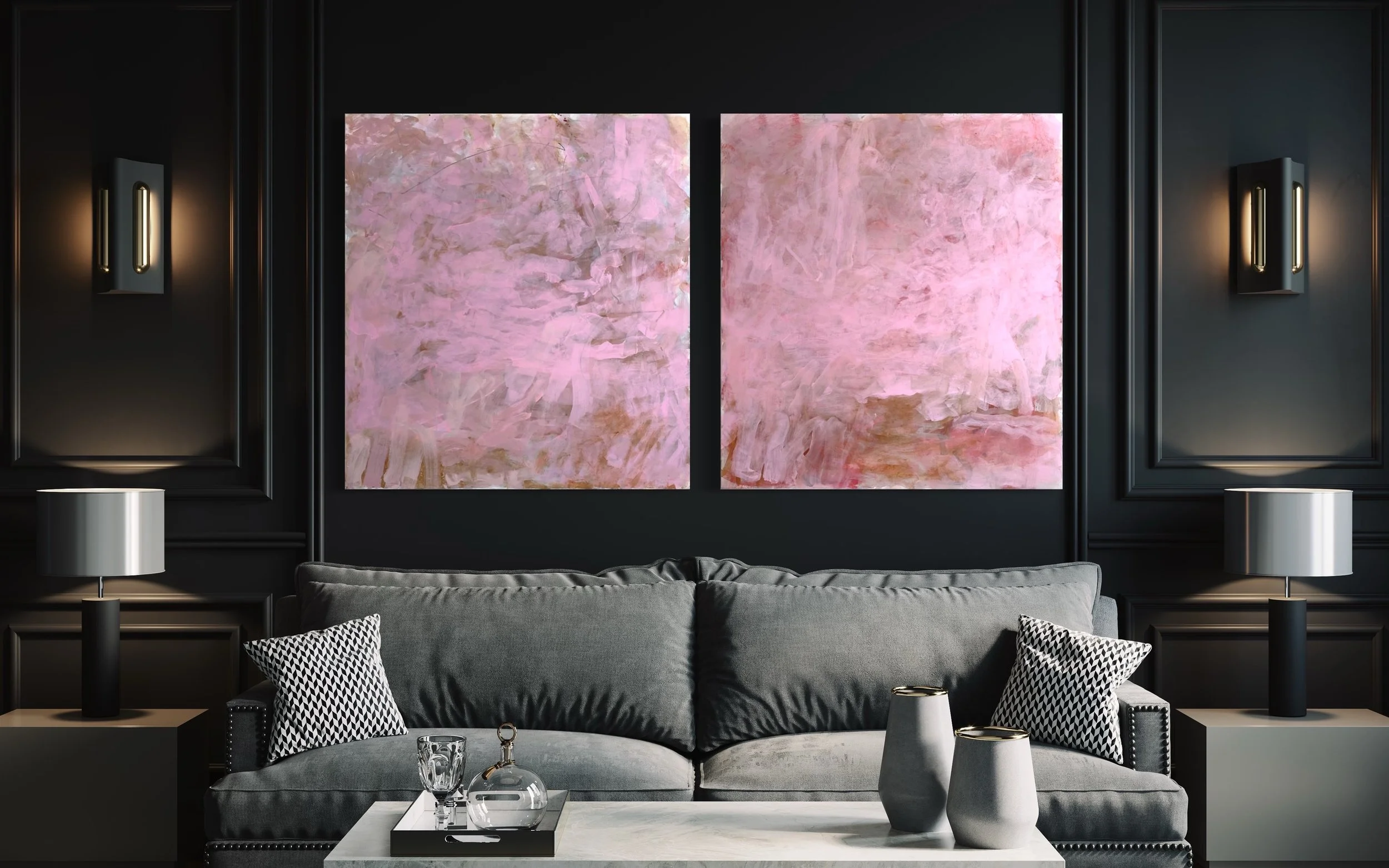 Modern living room with dark walls, two abstract pink paintings, a gray sofa, black and white throw pillows, and accessories on a white coffee table.