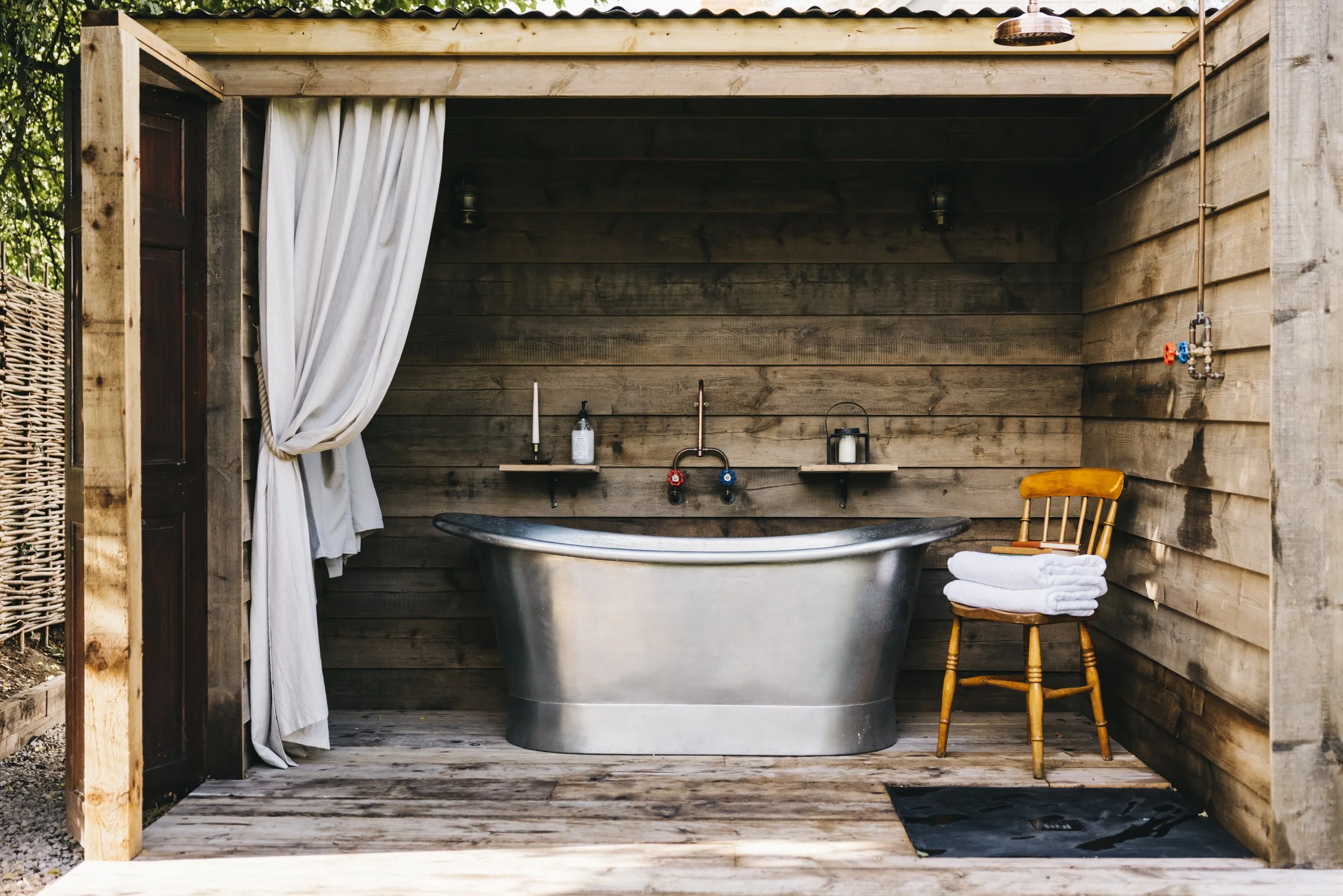 TheWorkersCottage_Norfolk_Outdoor Bath, Curtain, Chair with towels on top, Outdoor shower
