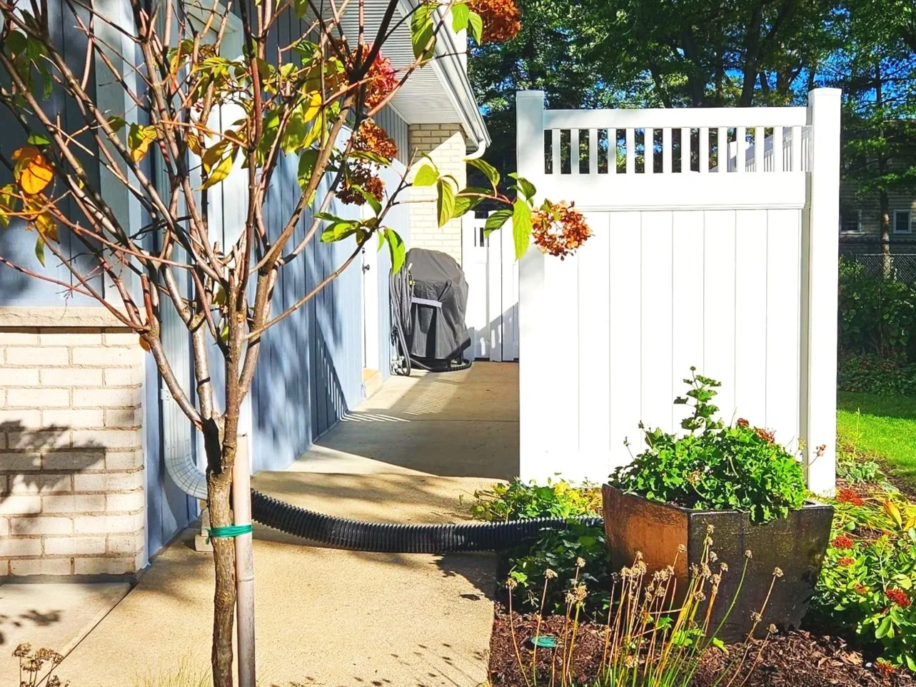 A white spindle top privacy vinyl fence surrounding the background.