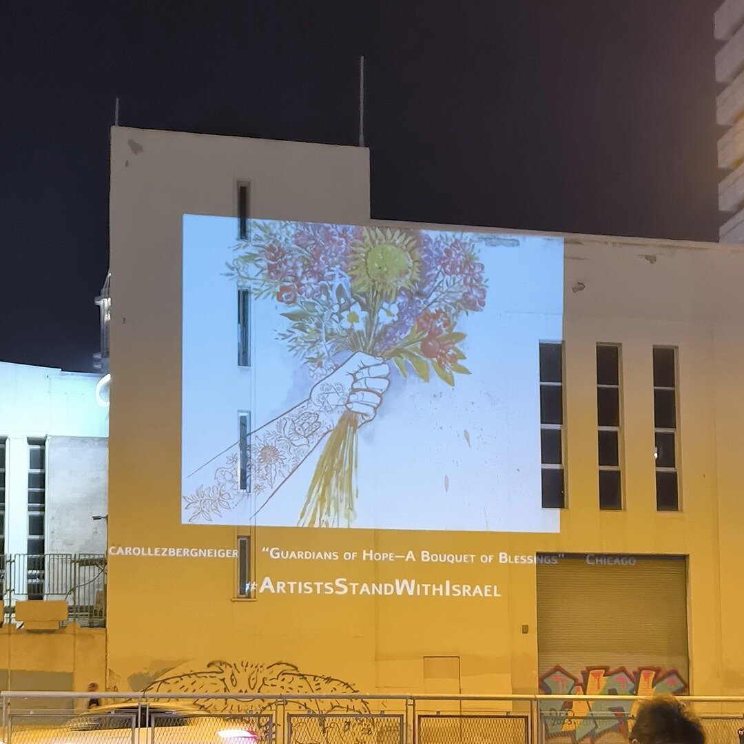 My artwork &quot;Guardians of Hope: A Bouquet of Blessings&quot; was projected on a building wall somewhere in Israel!

Photographed by Михаил Марушкин
#artistsstandwithisrael #hamsa #hope #israelhamaswar #protection #harmony #compassion #strength #p