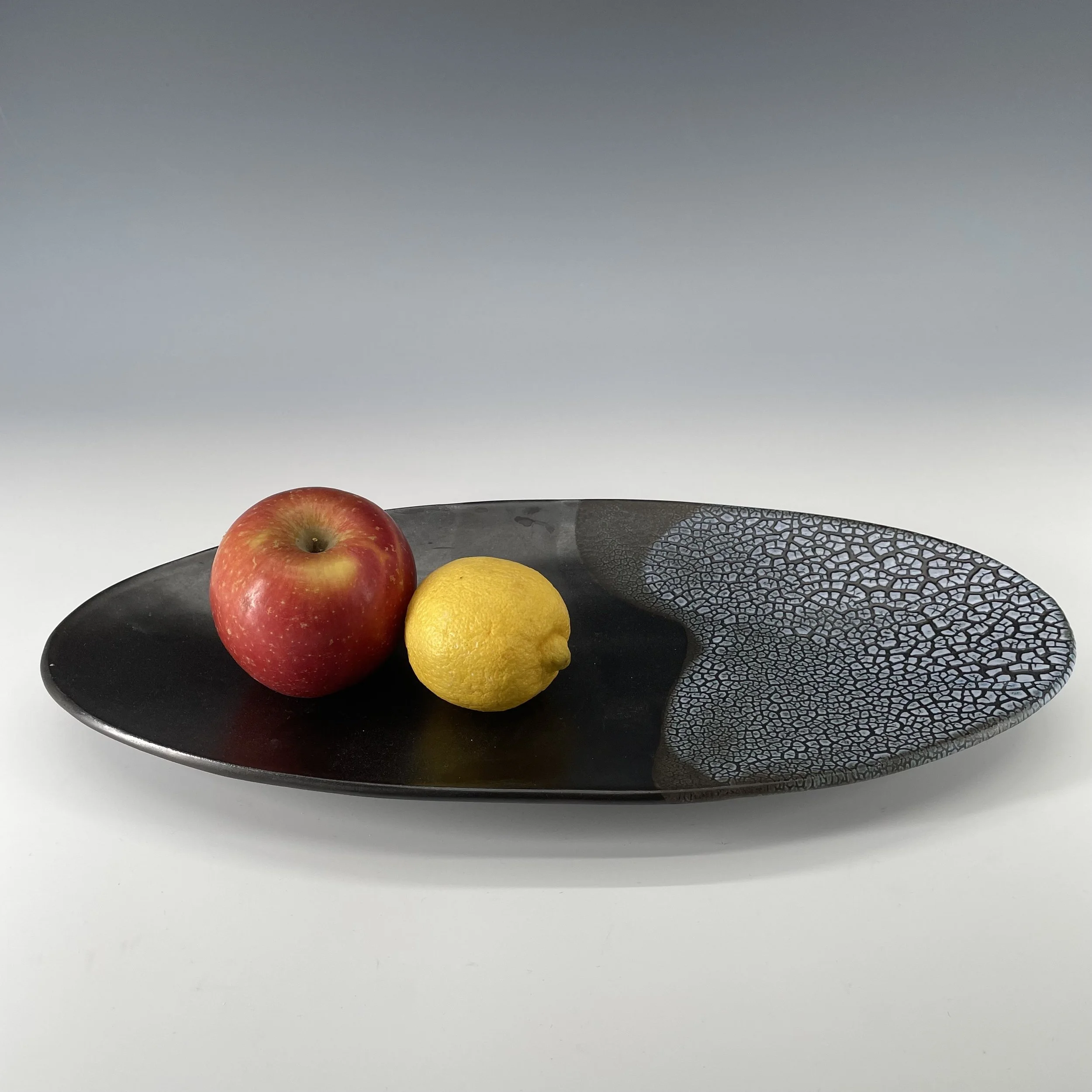 Black and crackle oval platter with fruit