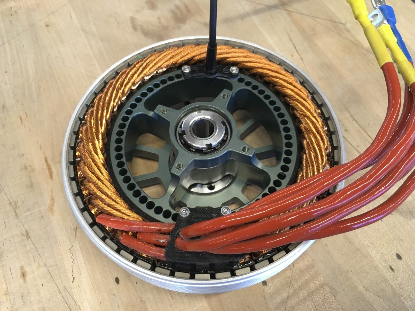  The motor has 6 phase leads exiting the rear which are combined into 3 phase pairs at the controller. The cable bundle exiting in the top of the photo contains the hall sensor signal wires and temperature sensor signal wires.  