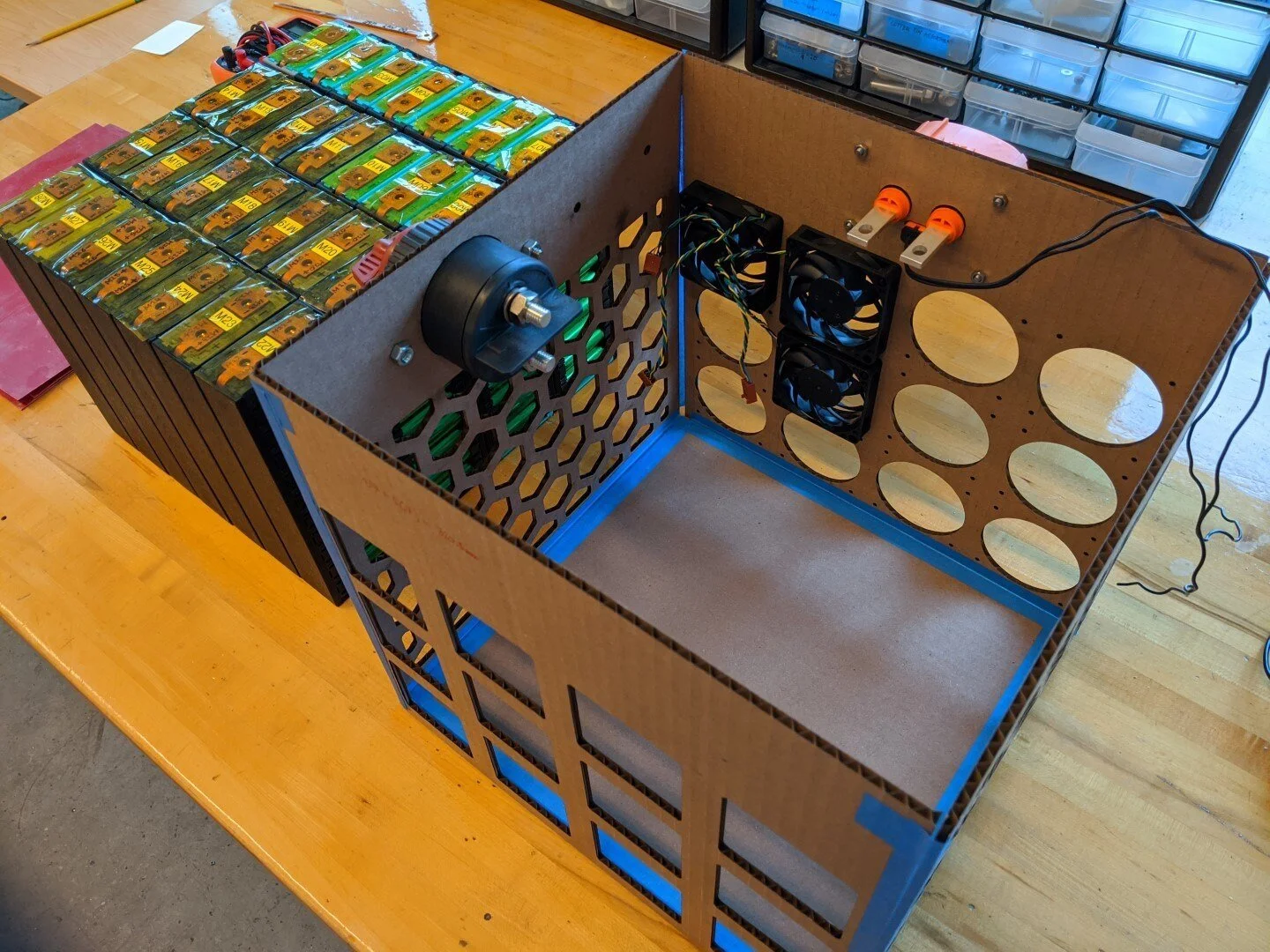 Cardboard prototype of the battery enclosure is evaluated prior to aluminum fabrication.