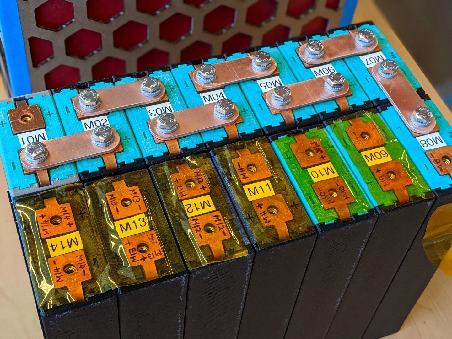 The modules are configured in series using copper terminal connectors secured with 1/4-20 fasteners and wedge lock washers (Nord-Locks). It's not obvious from the picture but each of the 7 modules in a row is mechanically interlocked with the adjac