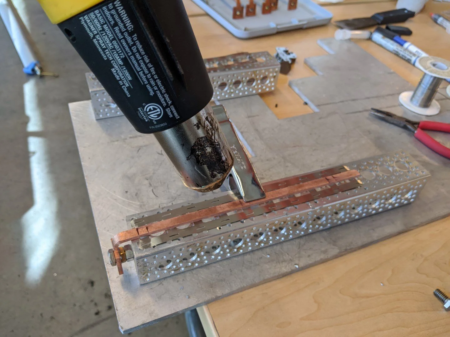 The nickel strip (0.2mm) is soldered to the the copper bus bar using heat gun and solder paste.