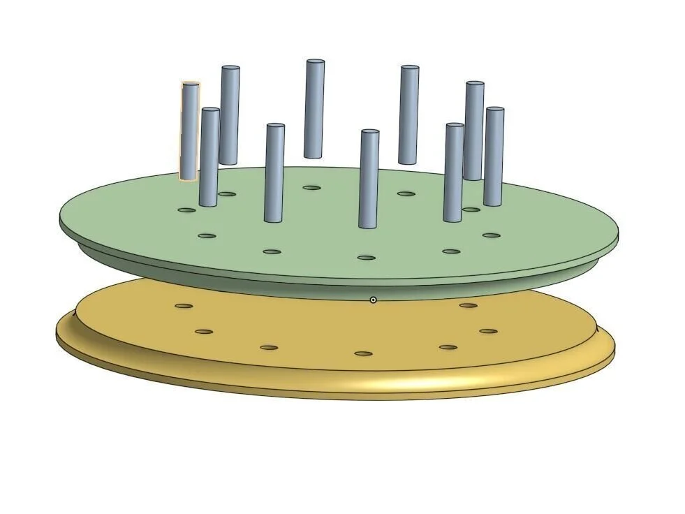 The bending jig is made from two 9-inch radius disks. Each disk is cut from 3/4" plywood and then the two halves are glued together. The dowels are used to align the disks prior to gluing.