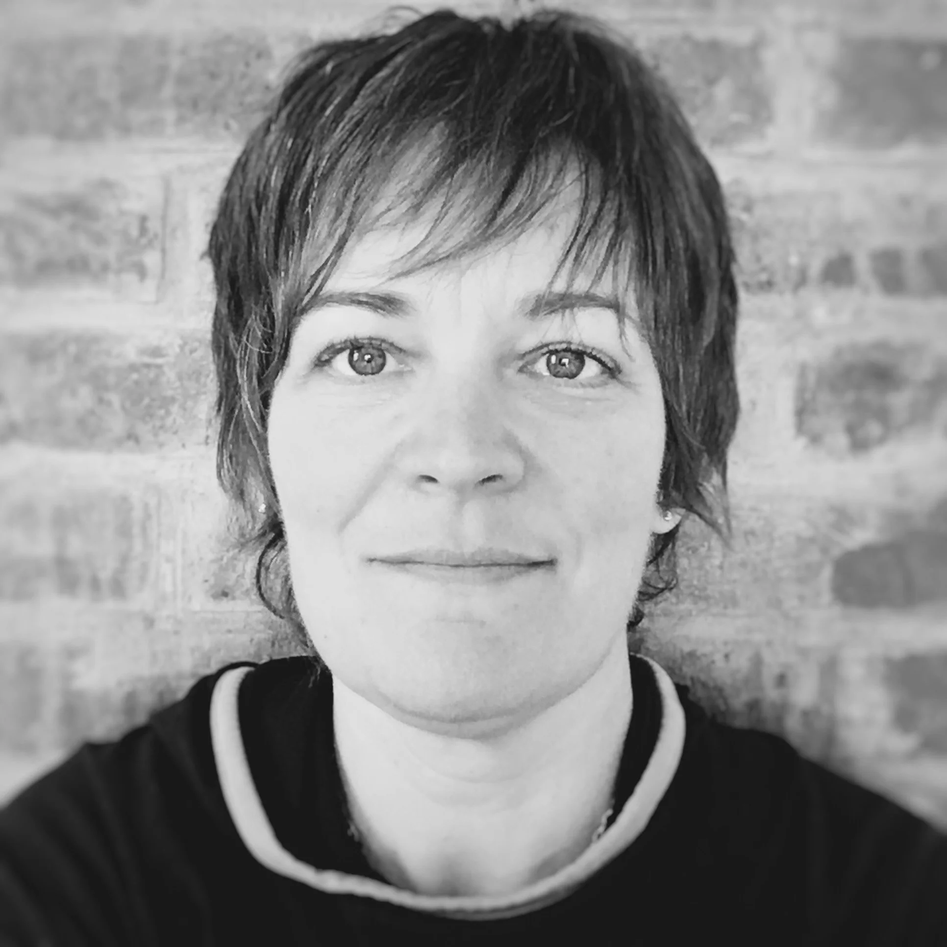 A portrait of fair coloured female with light coloured eyes and short brown hair.