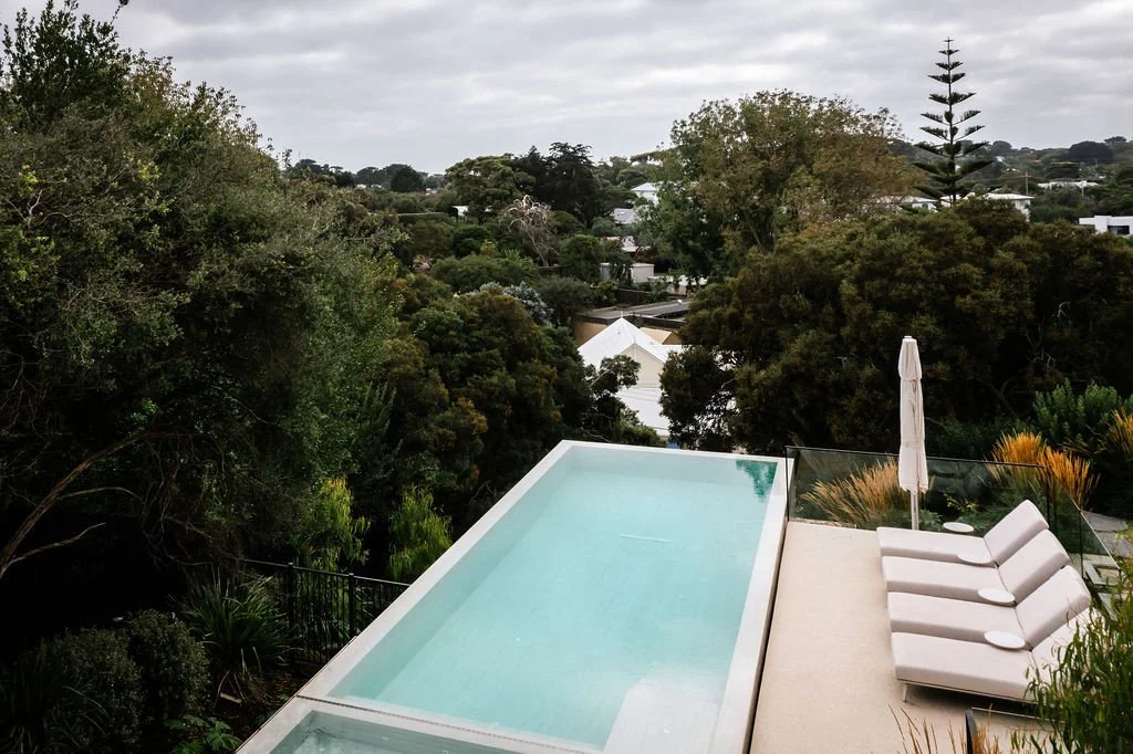 On a steep coastal block, the pool deck becomes a viewing platform as much as a place to swim. The borrowed landscape, with its coastal canopy stretching out toward the bay, is as much a part of this project as anything built.⁠
⁠
Landscapes design @a