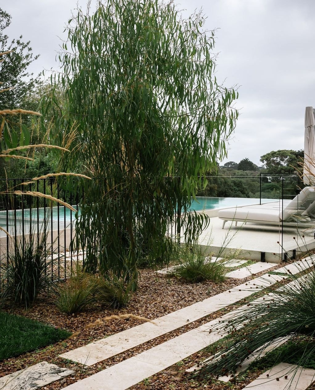 The travertine stepper path leads through the garden toward the pool.⁠
⁠
Set into gravel and softened with planting, the path shifts as you move through it.⁠
⁠
Landscape design @acre.landscape⁠
Pool @alohapools_aus⁠
📷 @janisalwayshashercamera