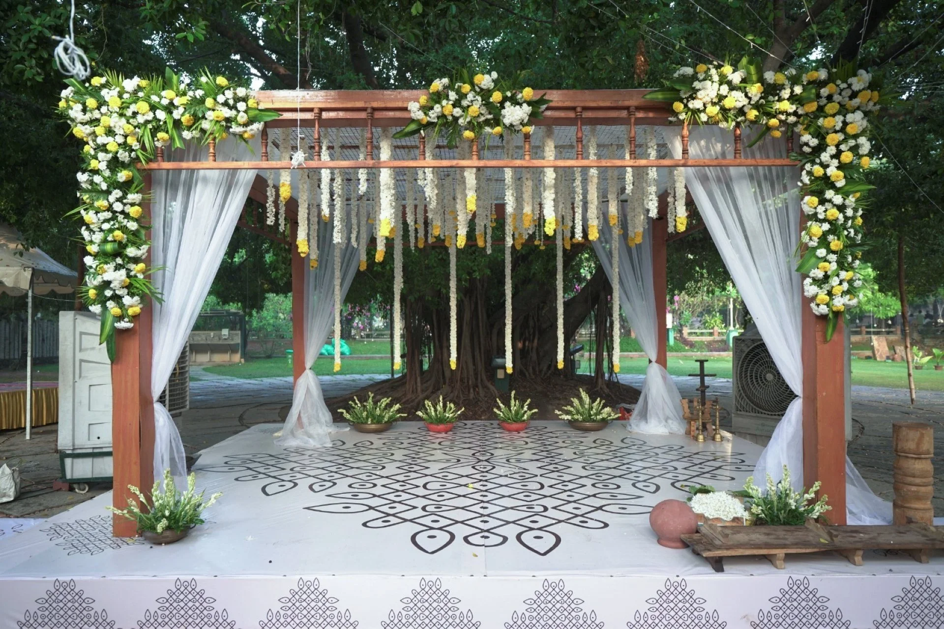 Daytime outdoor wedding ceremony at Ficus Lawn SPP Gardens Chennai with natural light and floral setup