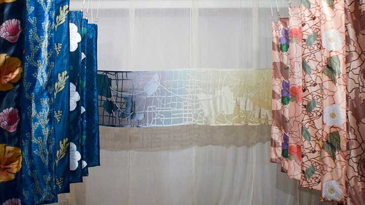 Full exhibit shot from listening booth of digital print map panels flanking hand-dyed devoré map