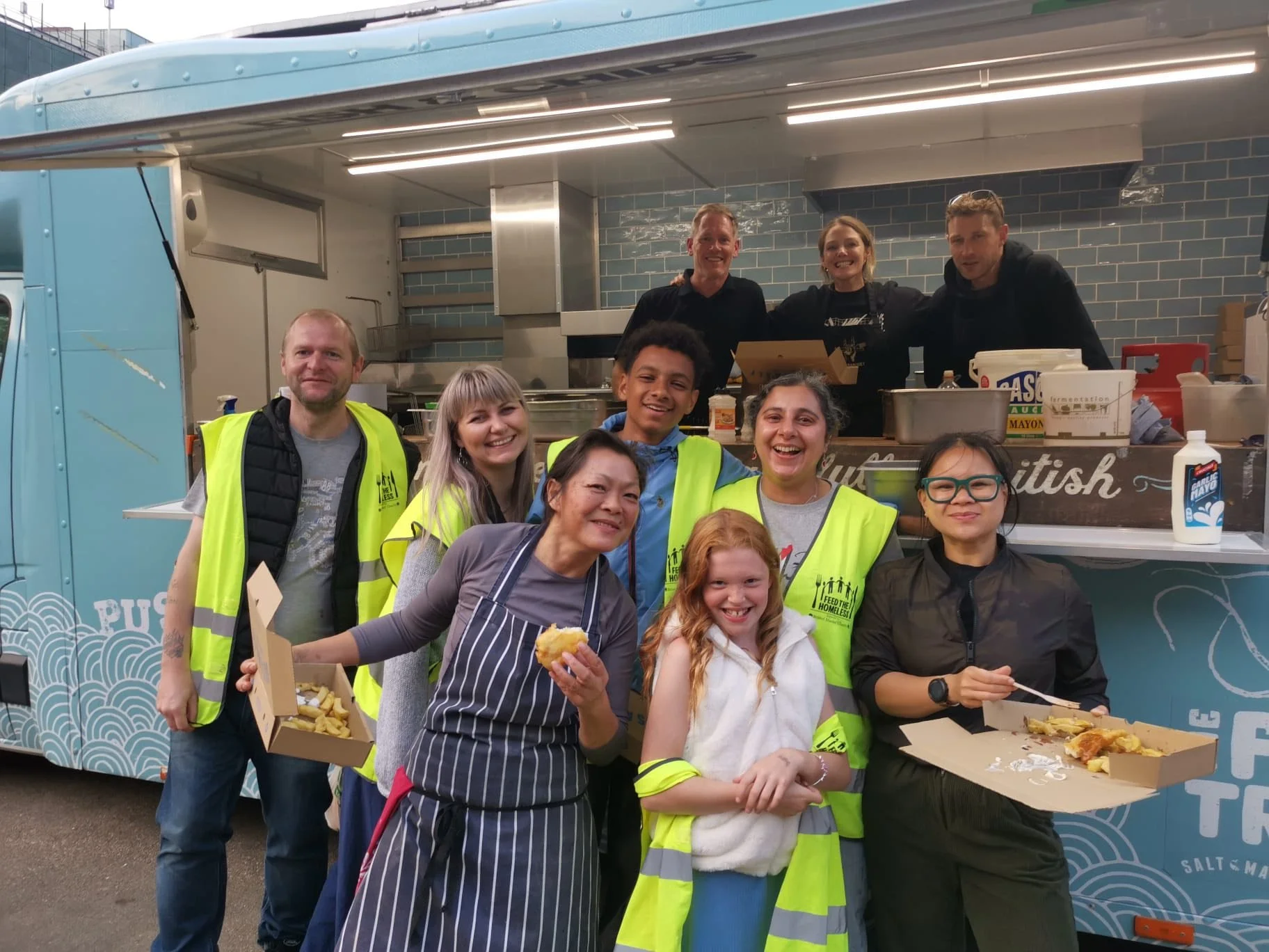 Members of Team Canteen, The Fish Truck and Feed the Homeless posing in in front of The Fish Truck