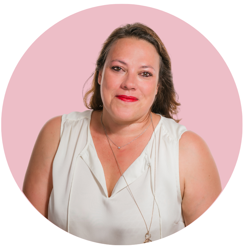 Une femme souriante portant un chemisier blanc avec un fond rose.