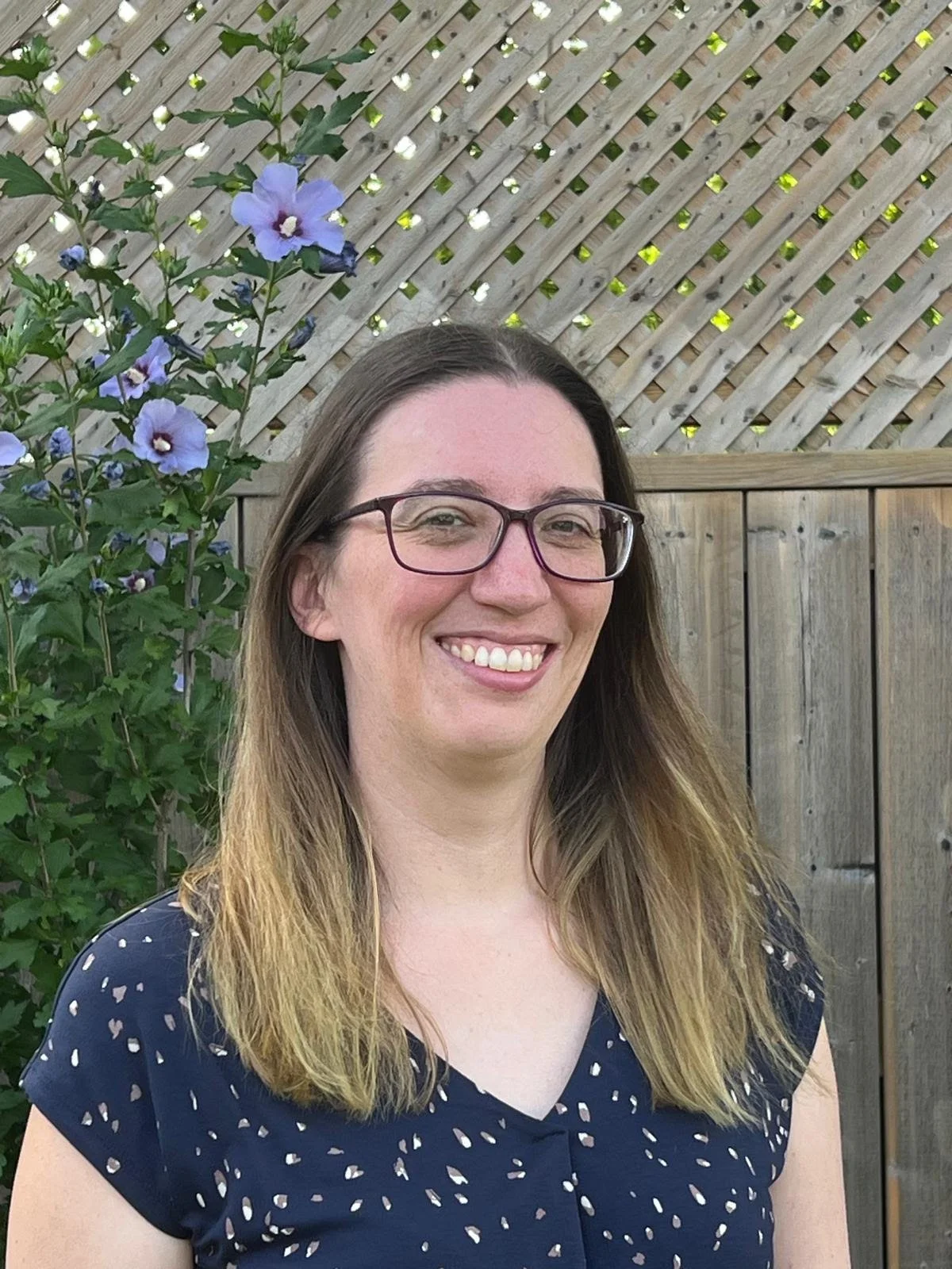 A white person with long hair and navy shirt 