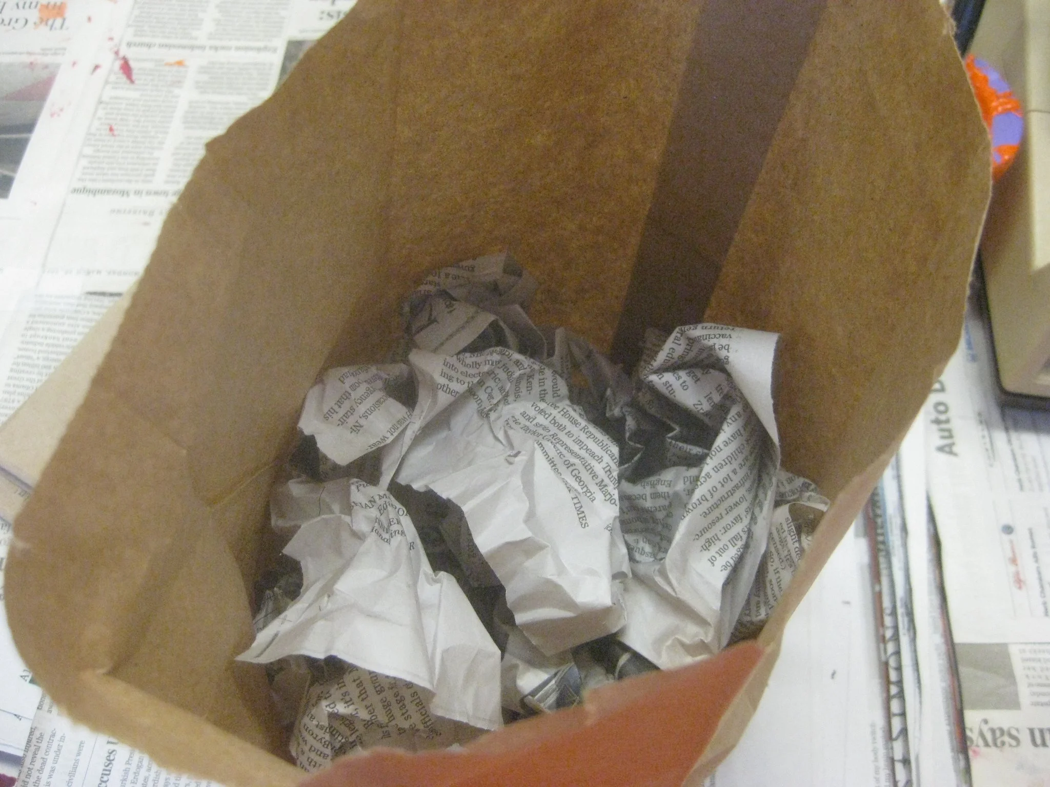 Balls of newspaper go into the paper bag.