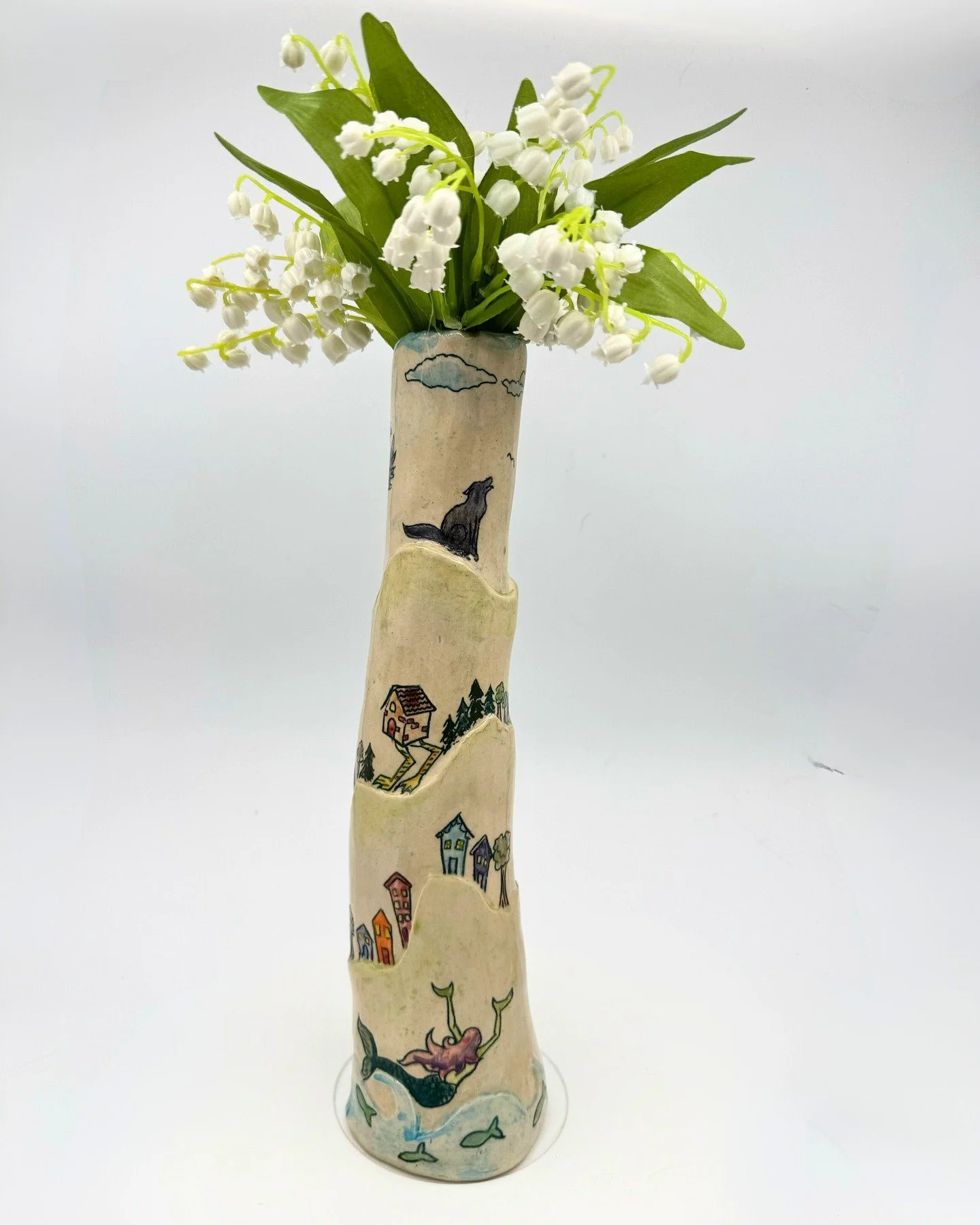 Three witches vase
Jordan Danger
2026

This is such a fun piece. I have mermaids enticing a seaside town, Baba Yaga's hut on a stroll, and Morrigan and her animals patrolling the moors. 

Yet the piece is facetiously sweet and cheerful.

Love me some