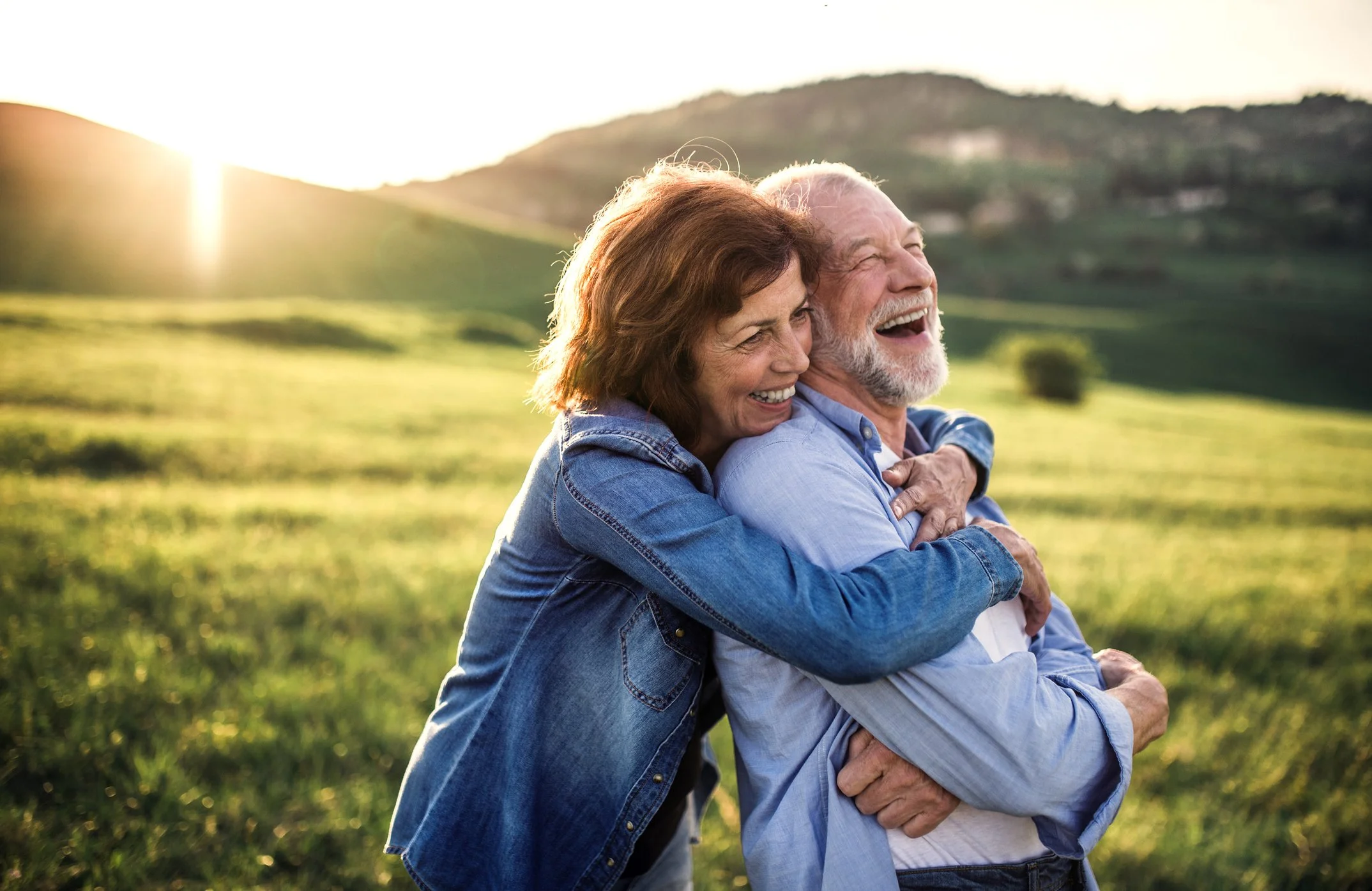 Laughing couple in Somerset enjoying conversation with their new hearing aids from Blackdown Hearing