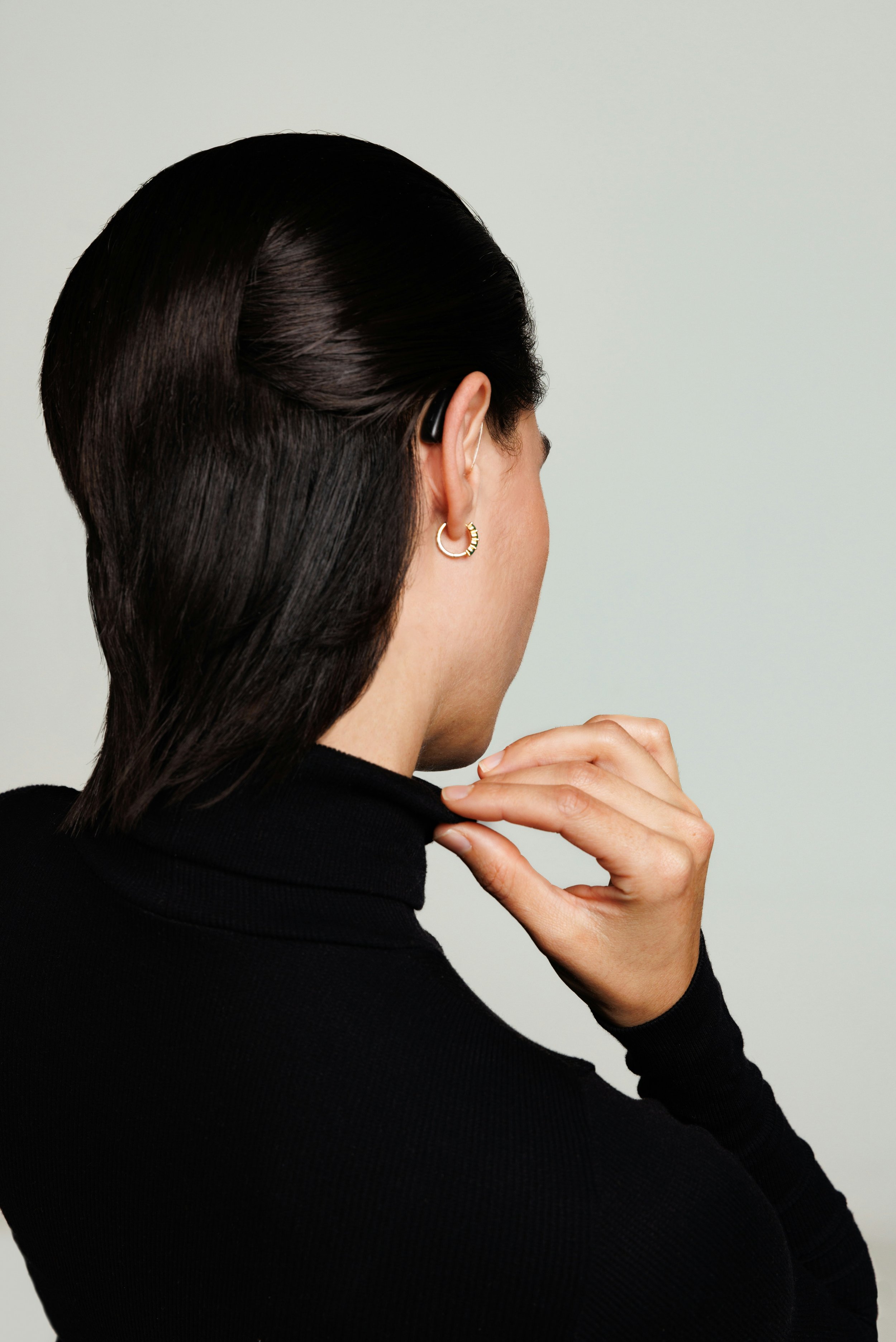 Rear view of a woman, wearing a discreet RIC hearing aid.