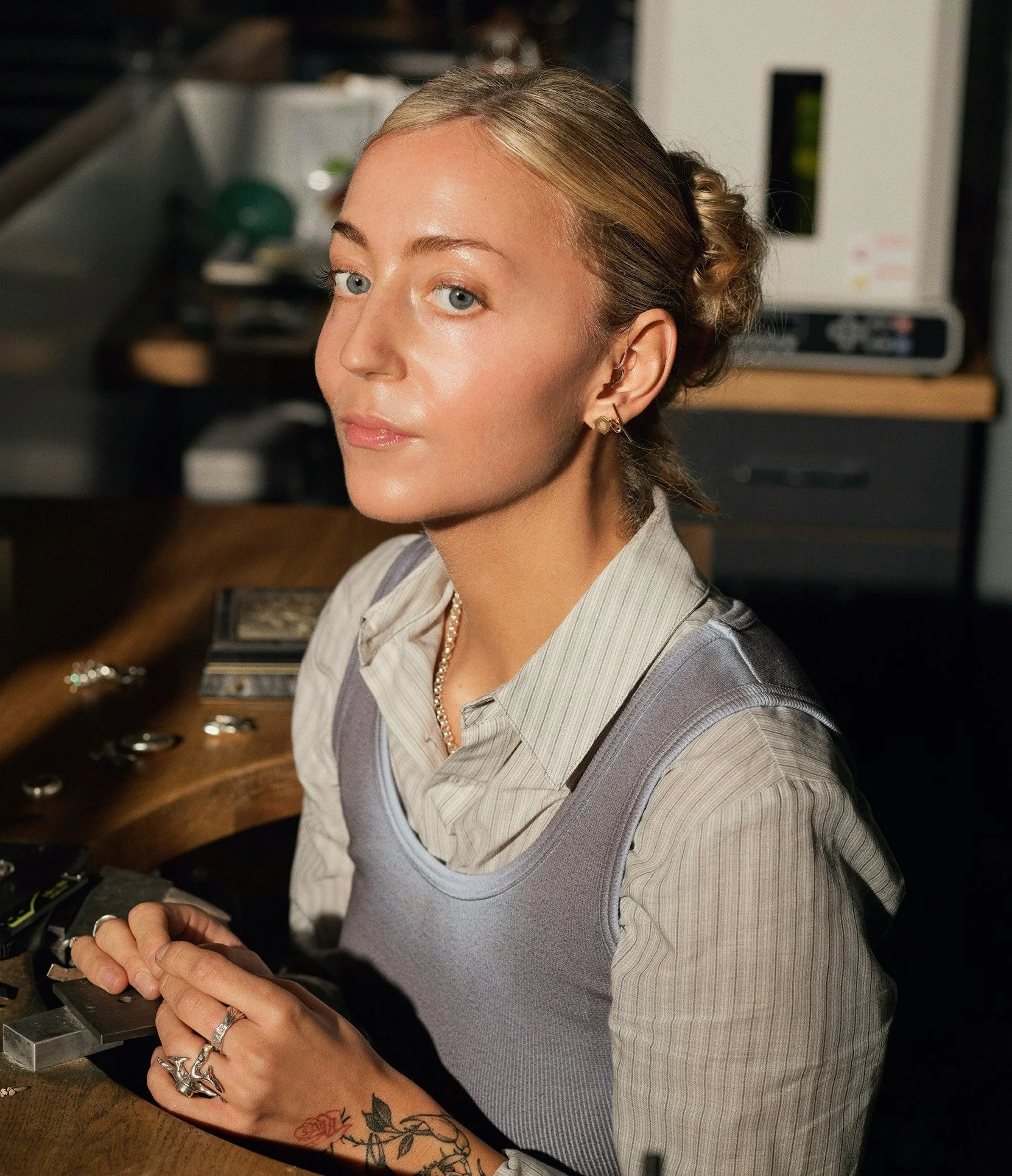 Young woman wearing a modern hearing aid while working, highlighting better hearing, communication confidence, and everyday independence.