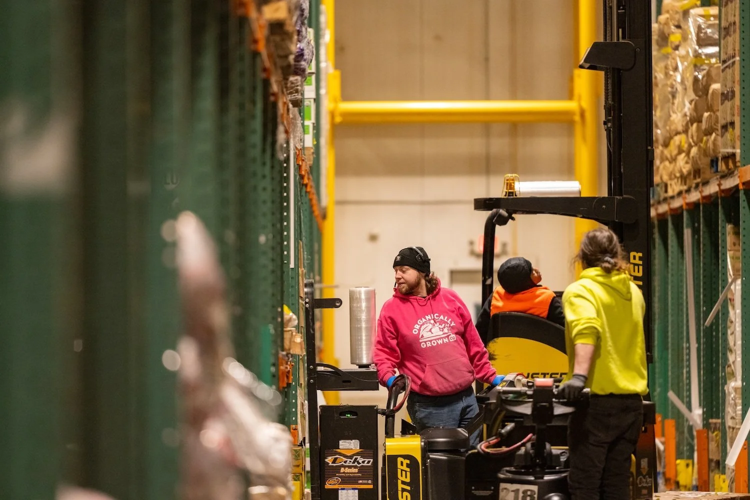 Employee driving forklift at warehouse facility