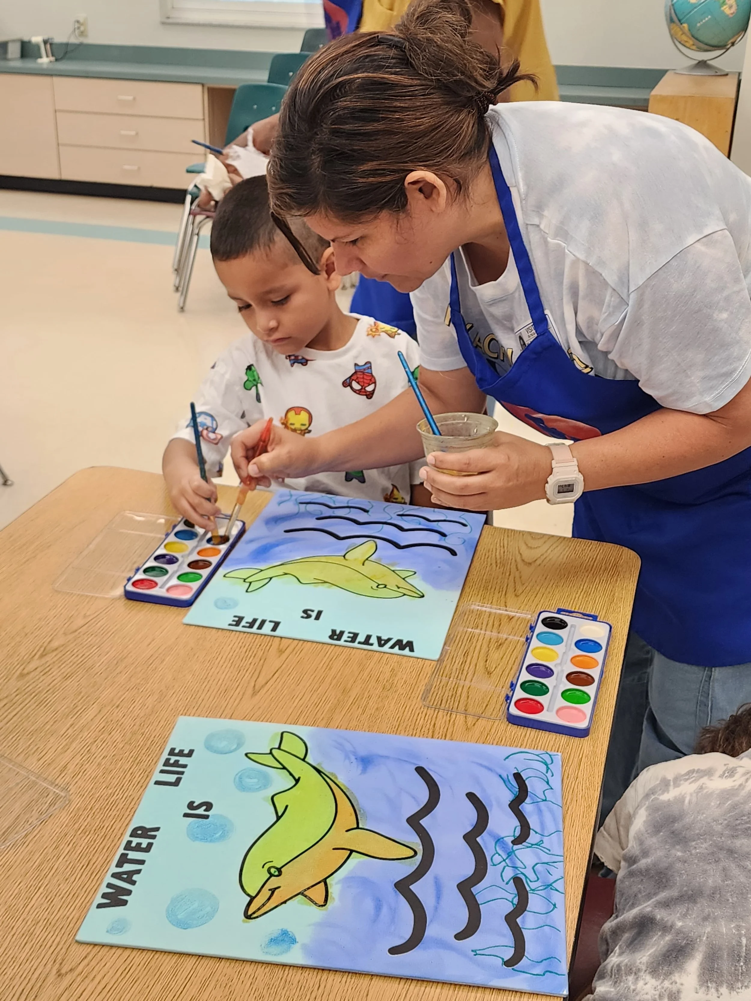 ceramics on wheels instructor helping a student with their artwork.JPG