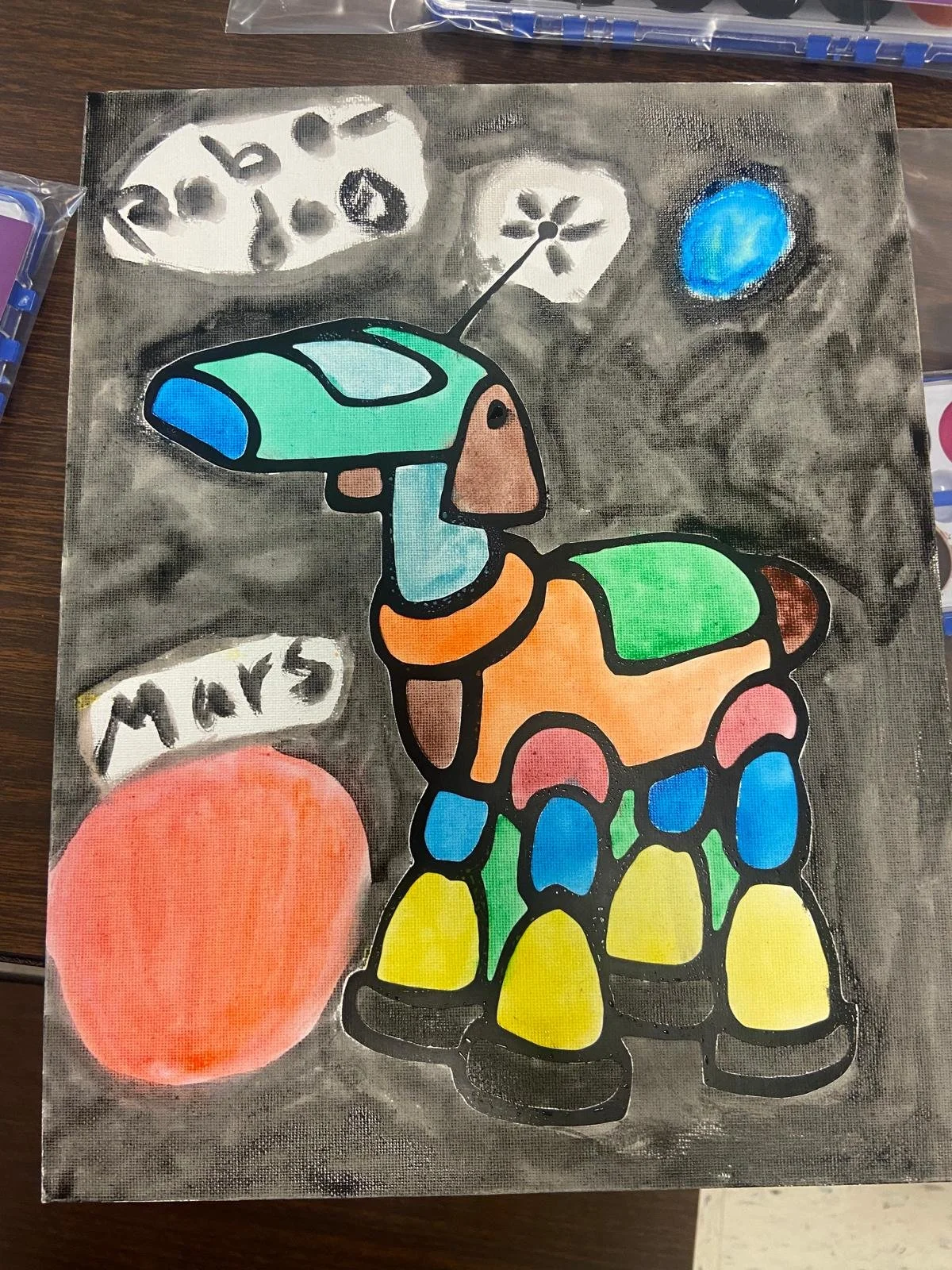 Colorful robot dog canvas painting created during a Ceramics on Wheels art workshop, featuring bright colors, creative patterns, and imaginative design elements.