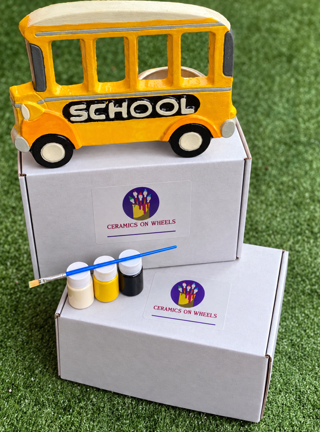 Ceramic school bus atop white boxes.png