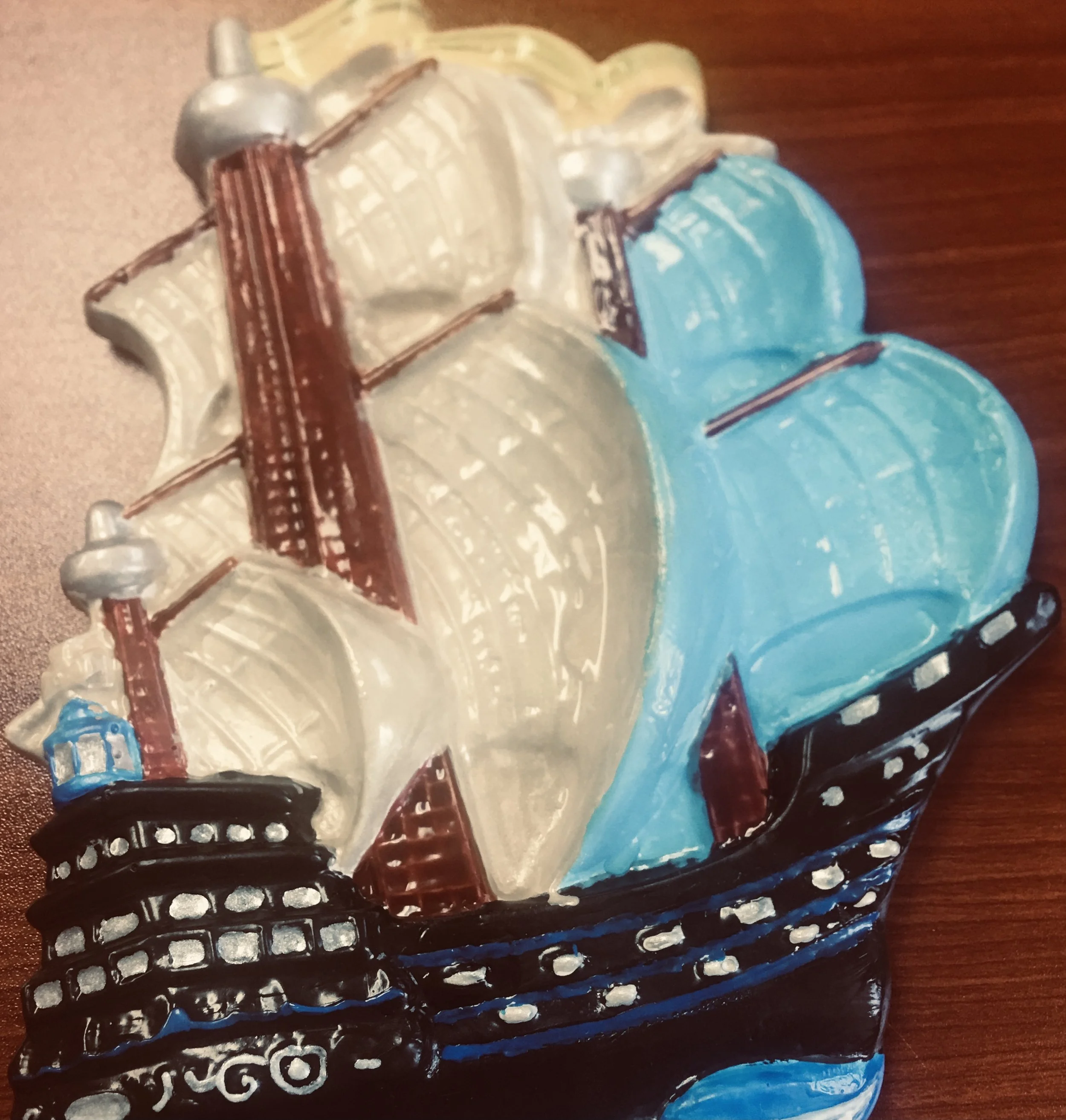 A painting of a cake with white, blue, and black icing, decorated with a guitar and a honey dipper on top of the cake.
