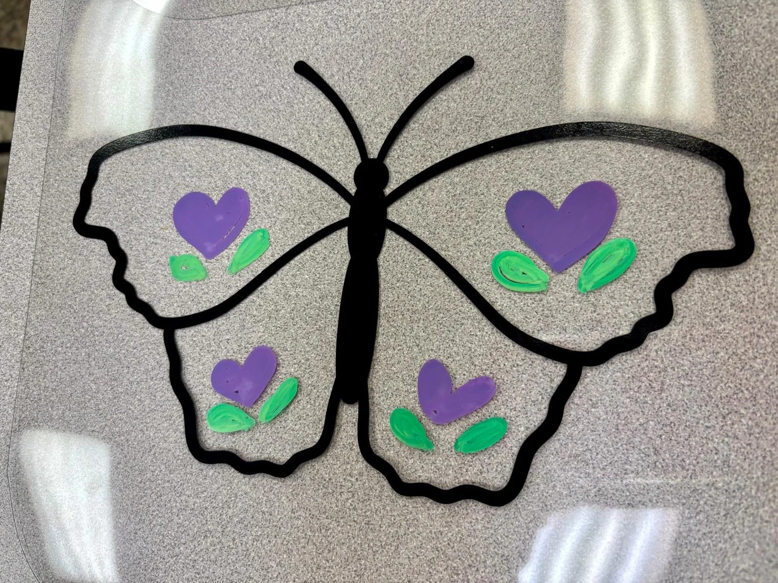 Butterfly sun catcher craft decorated with colorful designs during a Ceramics on Wheels mobile art activity in Hollywood, Florida.