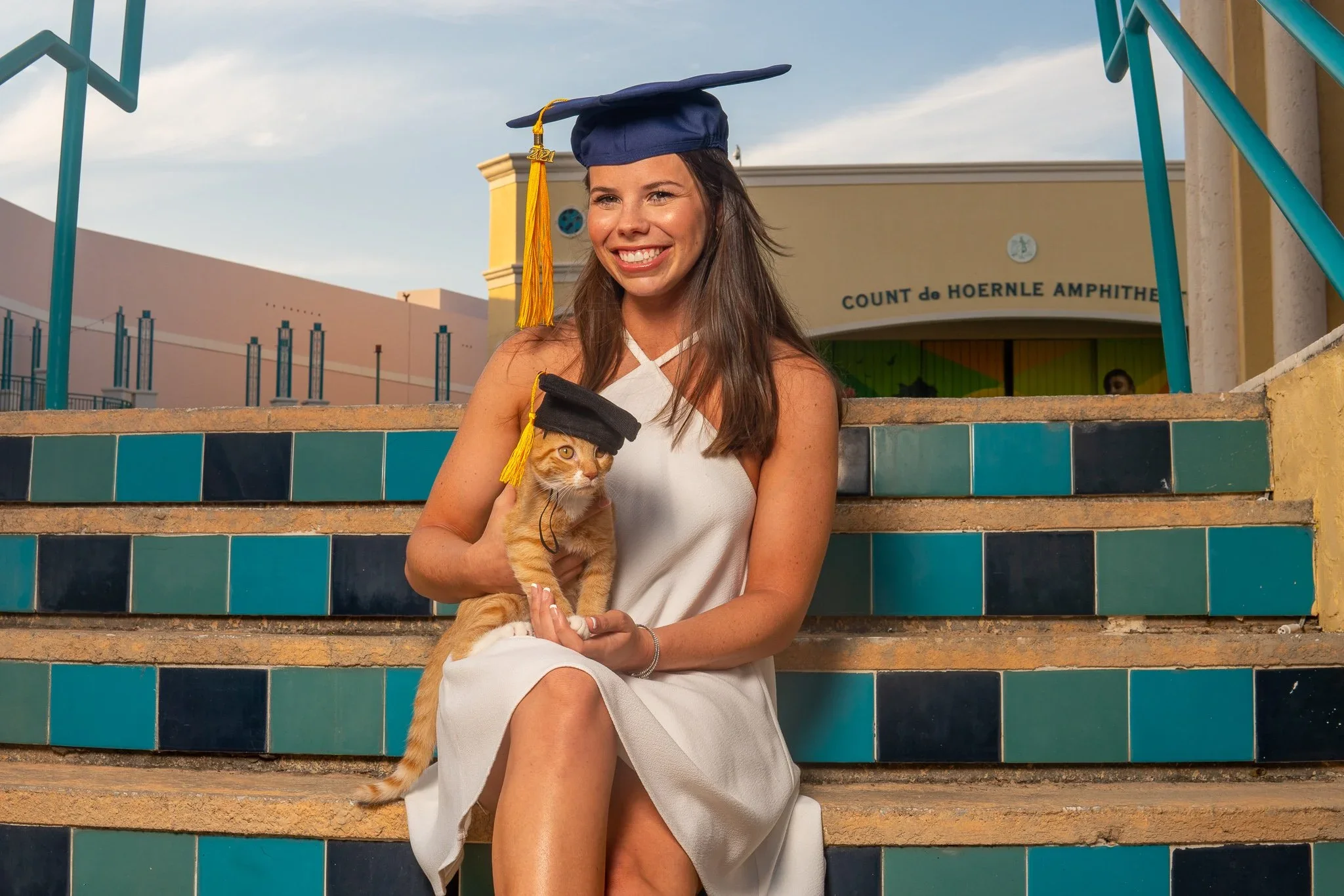 A graduate celebrating outside Mizner Park Amphitheater in Boca Raton