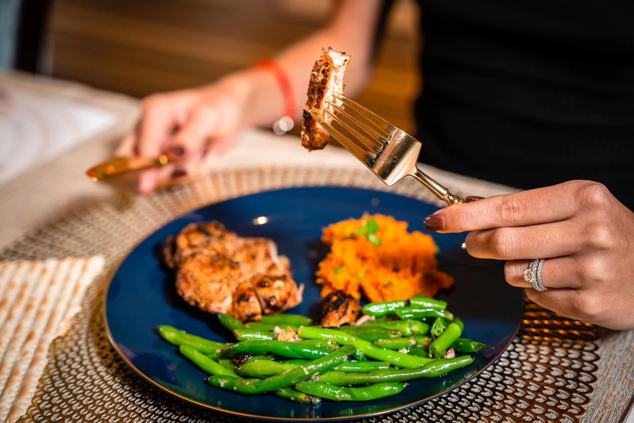 Customer cutting into a plated entrée with vegetables