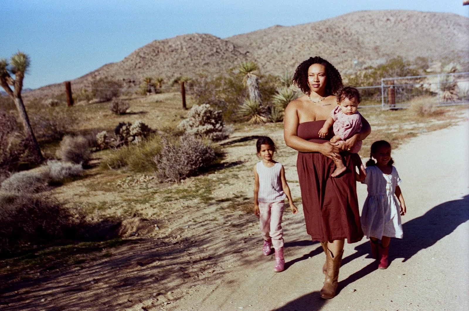 mom and children walking through joshua tree on gravel drive