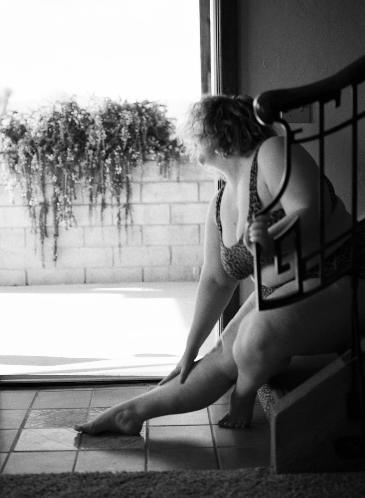 black and white photo of a woman sitting on the stairs modeling for 4x4 workshop