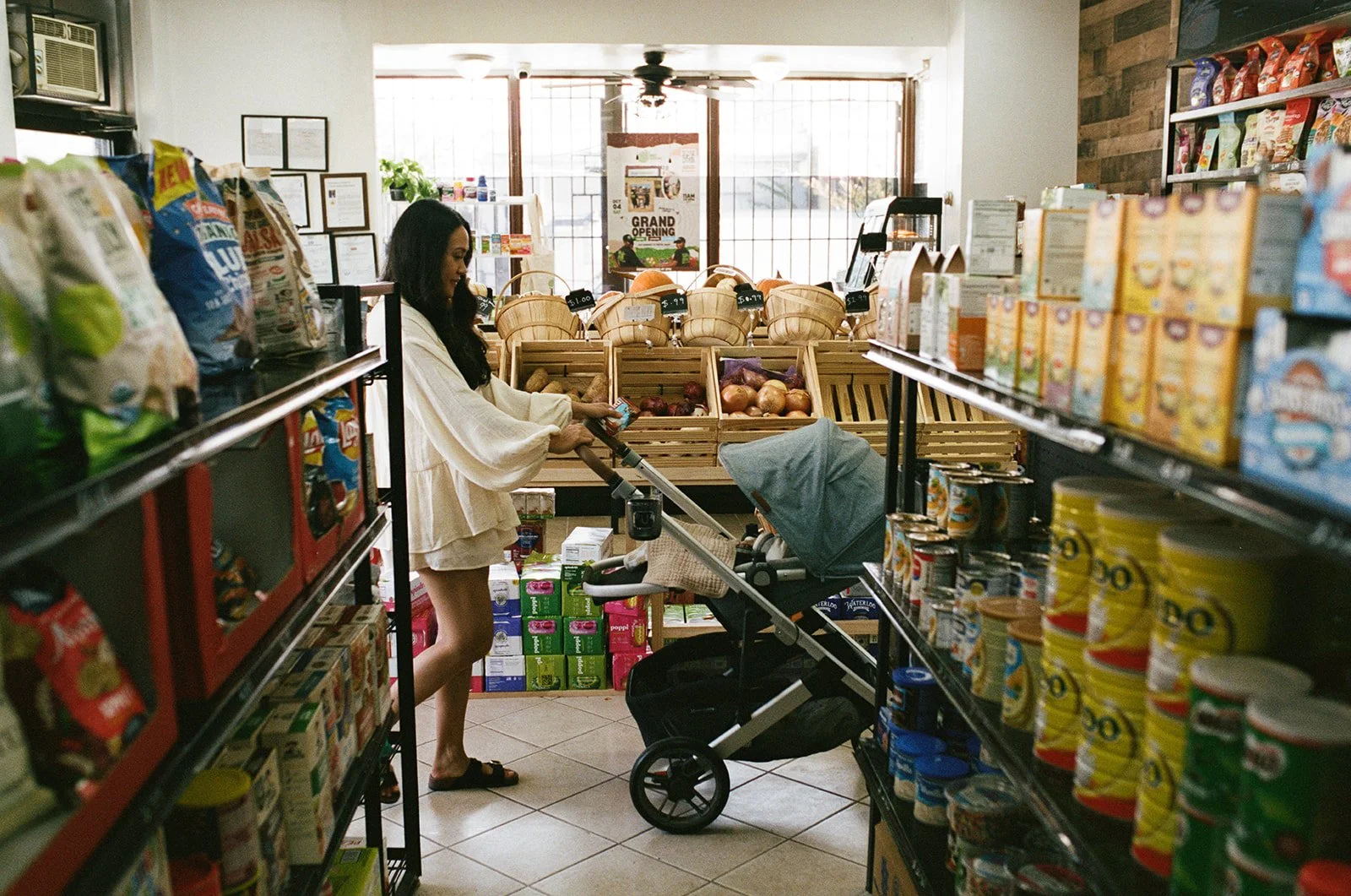 a mother pushes her baby stroller through the supermarket while on an outing during their newborn photography session at home 