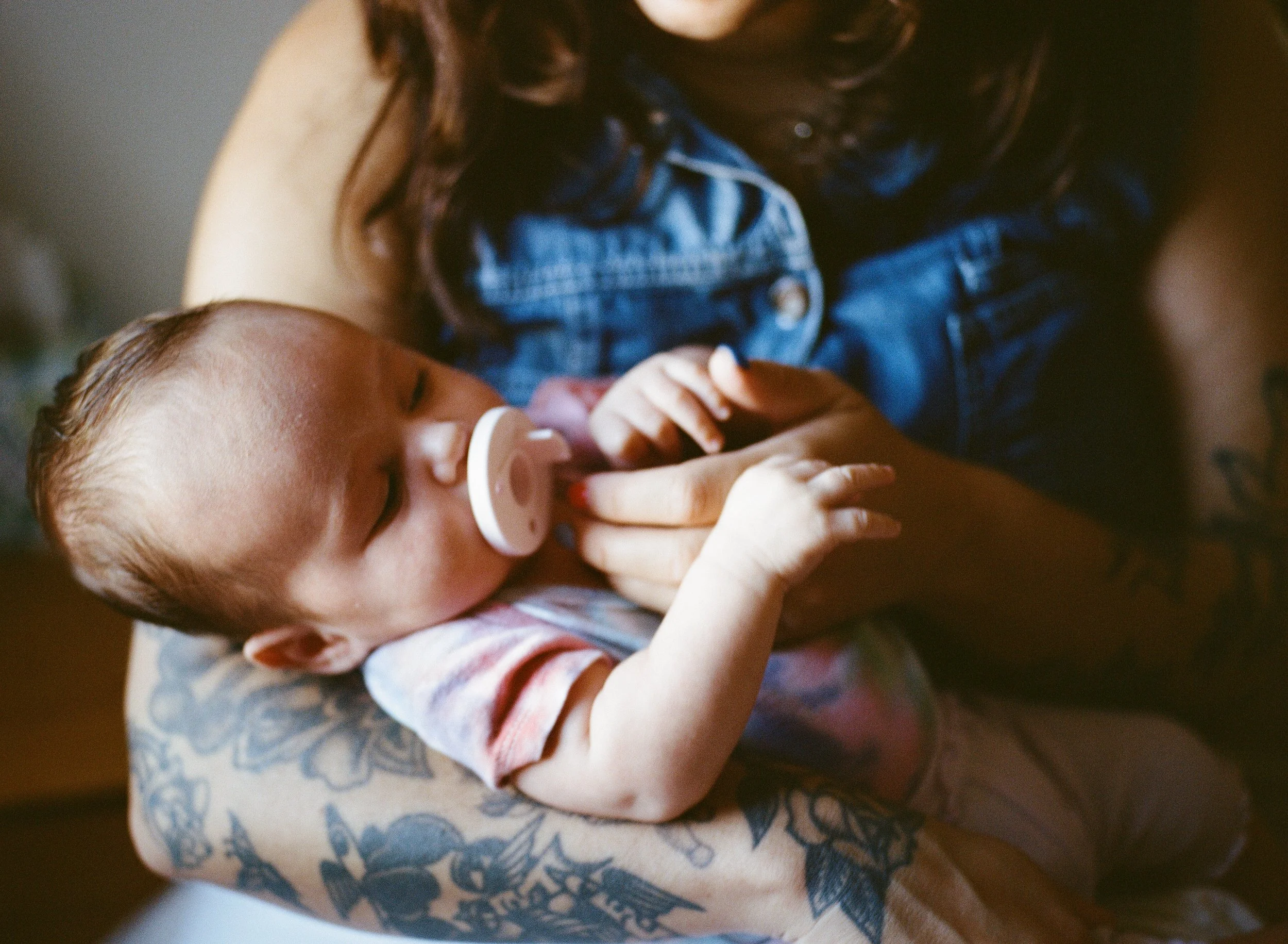 Close of up a mother holding her sleeping infant while she naps. 