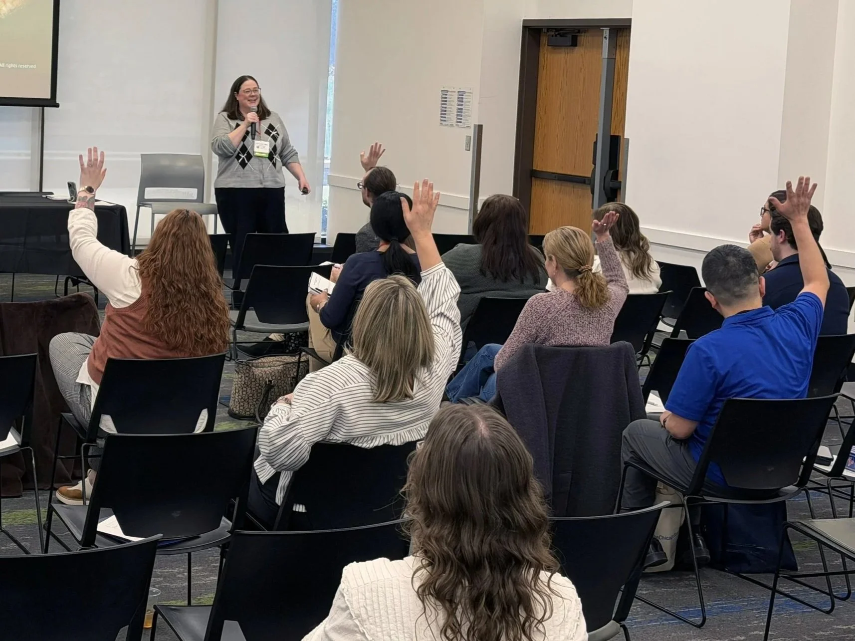 Dr. Porter in front of an audience with raised hands
