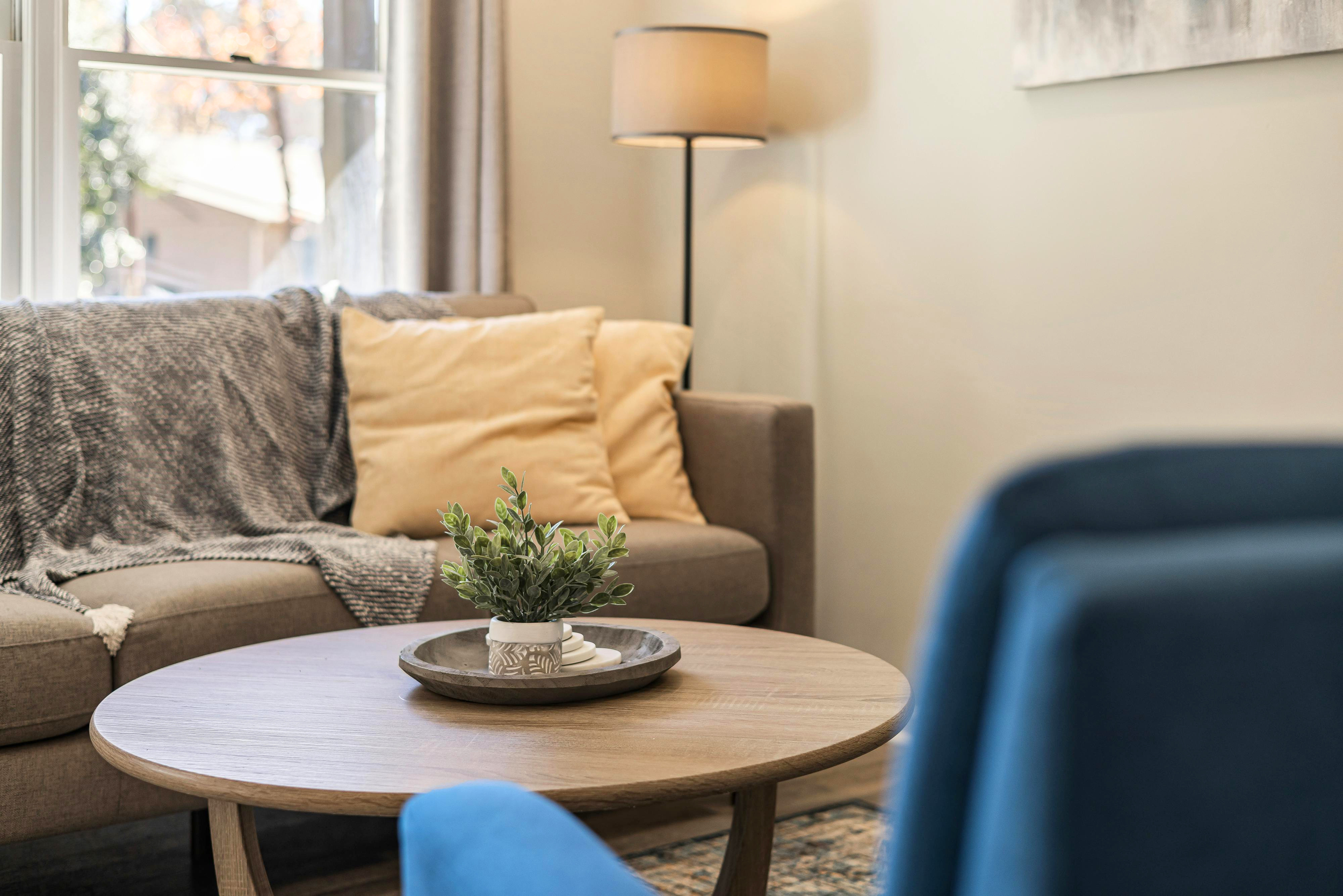 Closeup of sofa with coffee table and chair in foreground