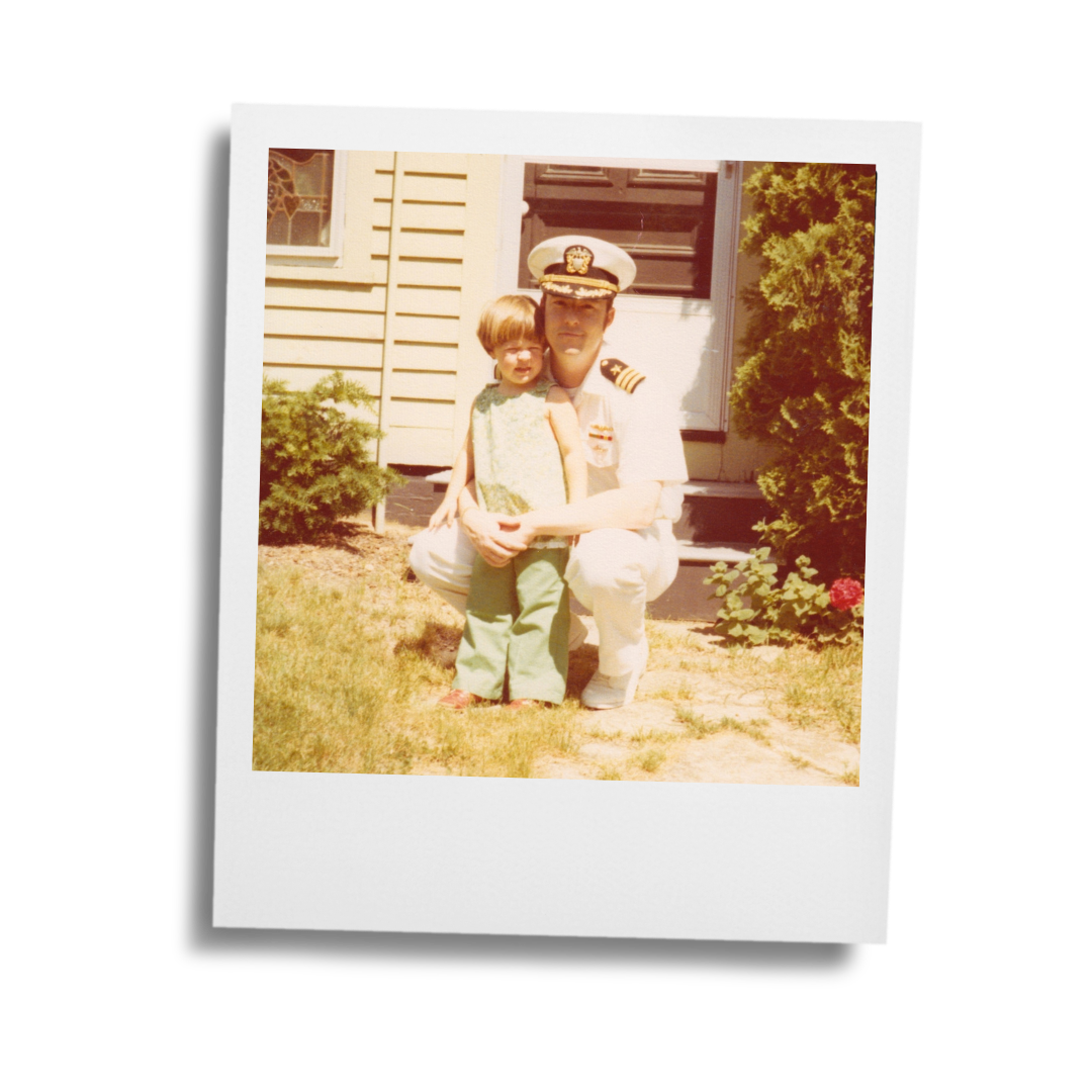 A toddler and man in a white US Navy uniform